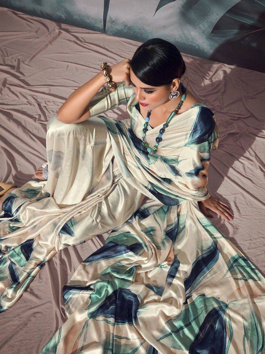 Elegant woman in designer saree with green and blue abstract print, styled with statement jewelry for ethnic wear.
