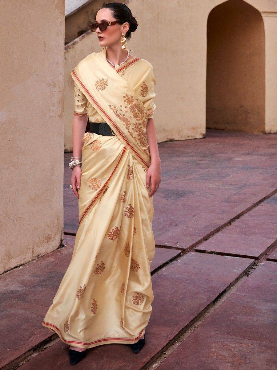 Elegant cream saree with gold floral embroidery, styled with black belt and heels for ethnic wear