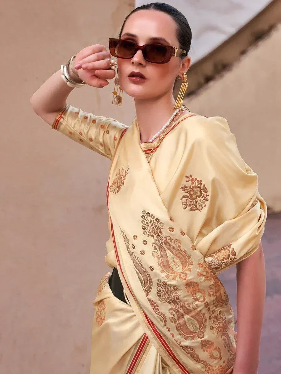Elegant cream saree with gold paisley print, styled with sunglasses and pearl jewelry for a modern ethnic look.