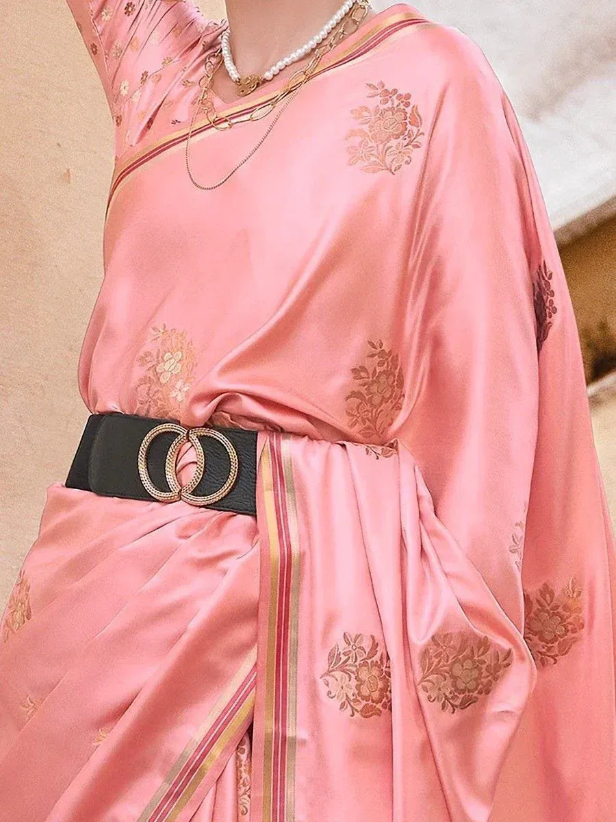 Pink satin saree with gold floral embroidery, black belt, and pearl necklace