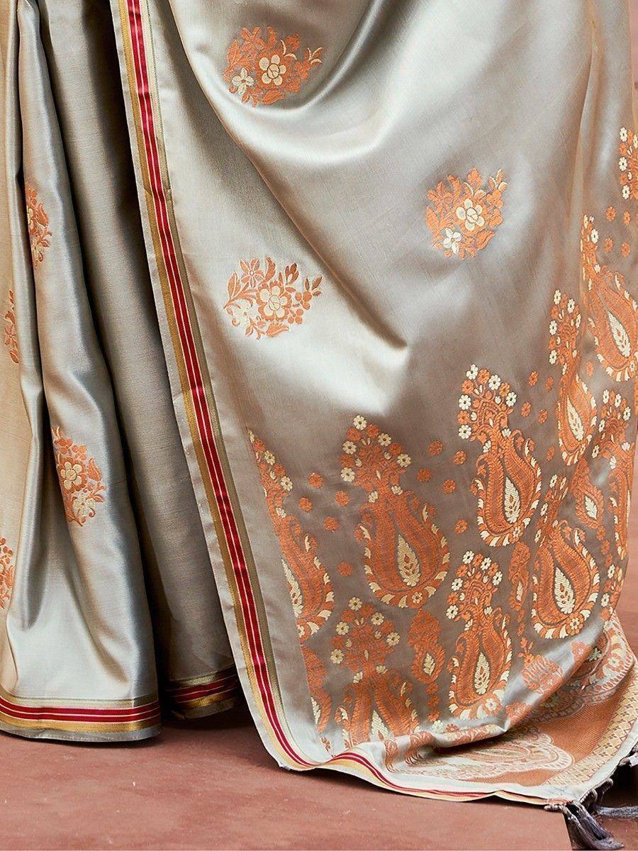 Elegant beige saree with orange paisley and floral embroidery, perfect for Indian ethnic wear occasions.