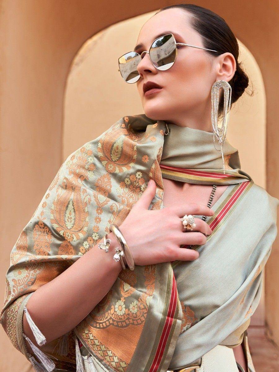 Elegant woman in olive green saree with gold paisley print, statement earrings, and sunglasses