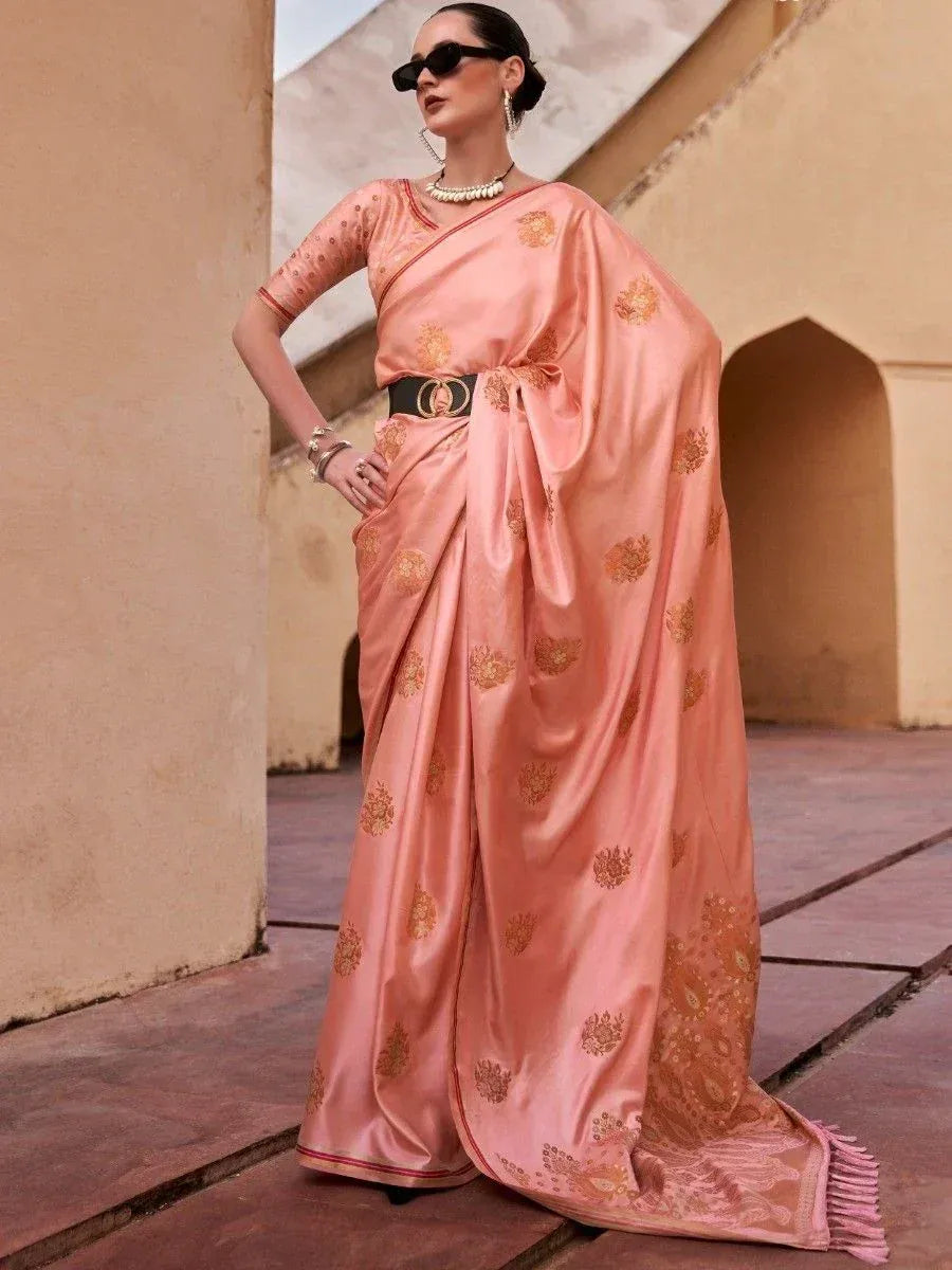 Elegant peach saree with gold floral motifs, styled with belt and statement jewelry for ethnic wear
