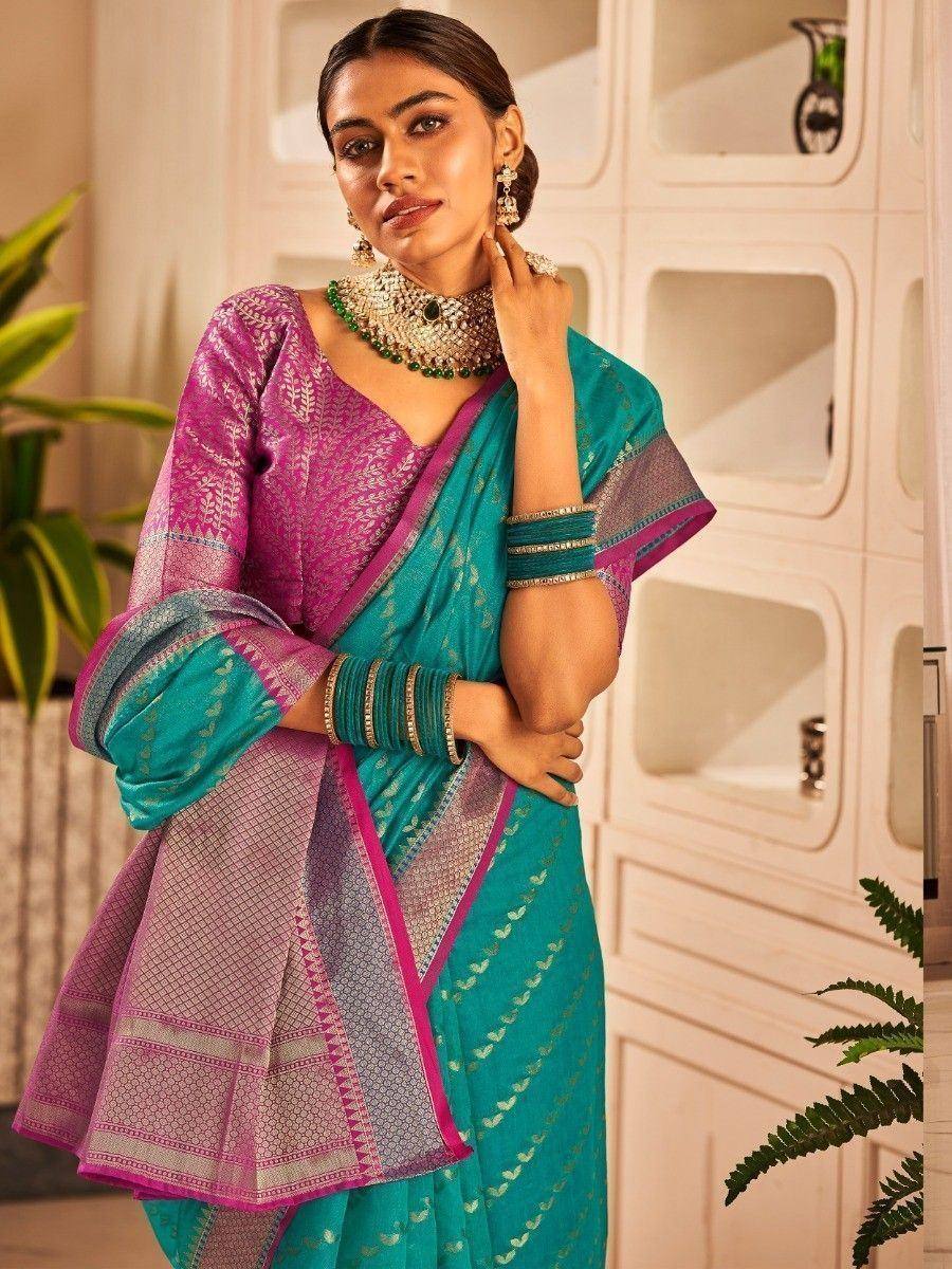 Teal and pink designer saree with intricate embroidery and traditional jewelry for ethnic occasions