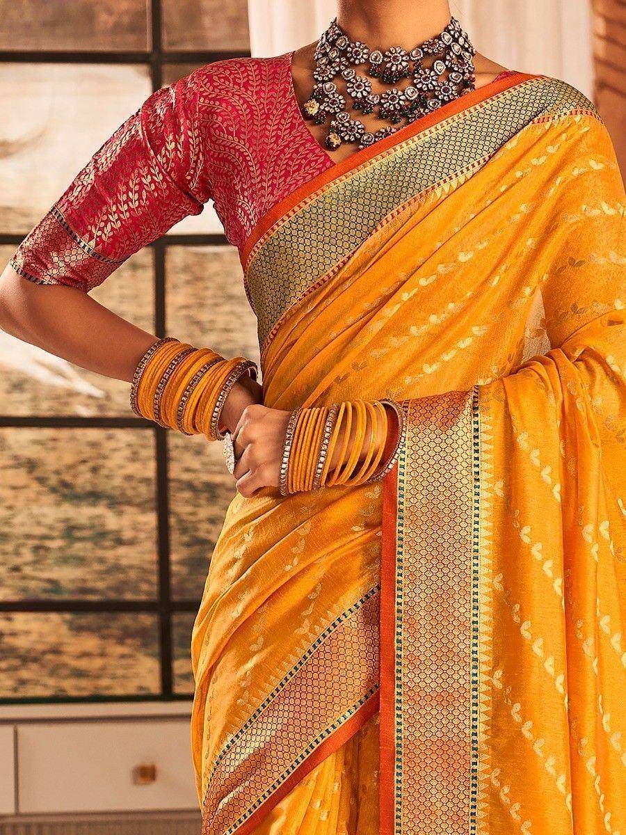 Vibrant yellow saree with geometric border, paired with red printed blouse and traditional jewelry