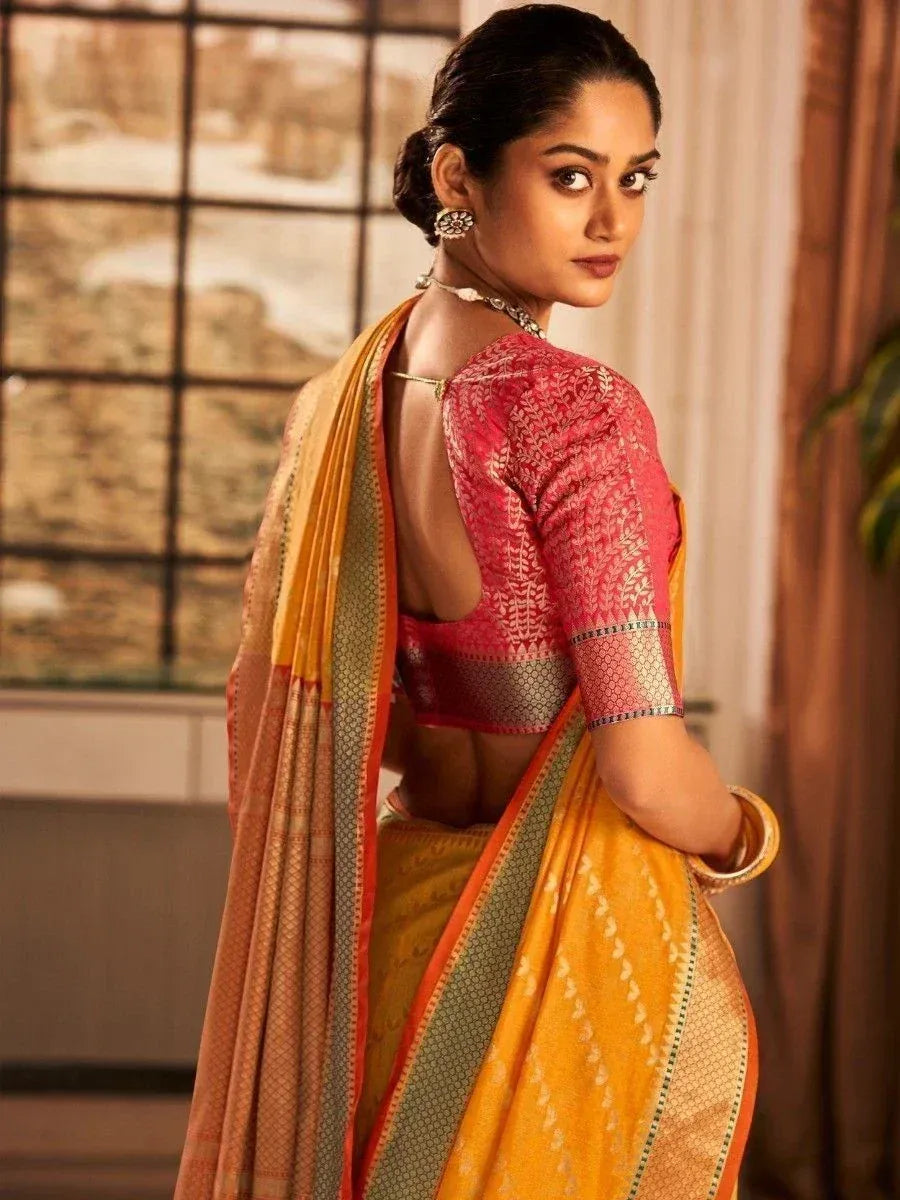 Woman in vibrant yellow saree with pink embroidered blouse, traditional Indian ethnic wear
