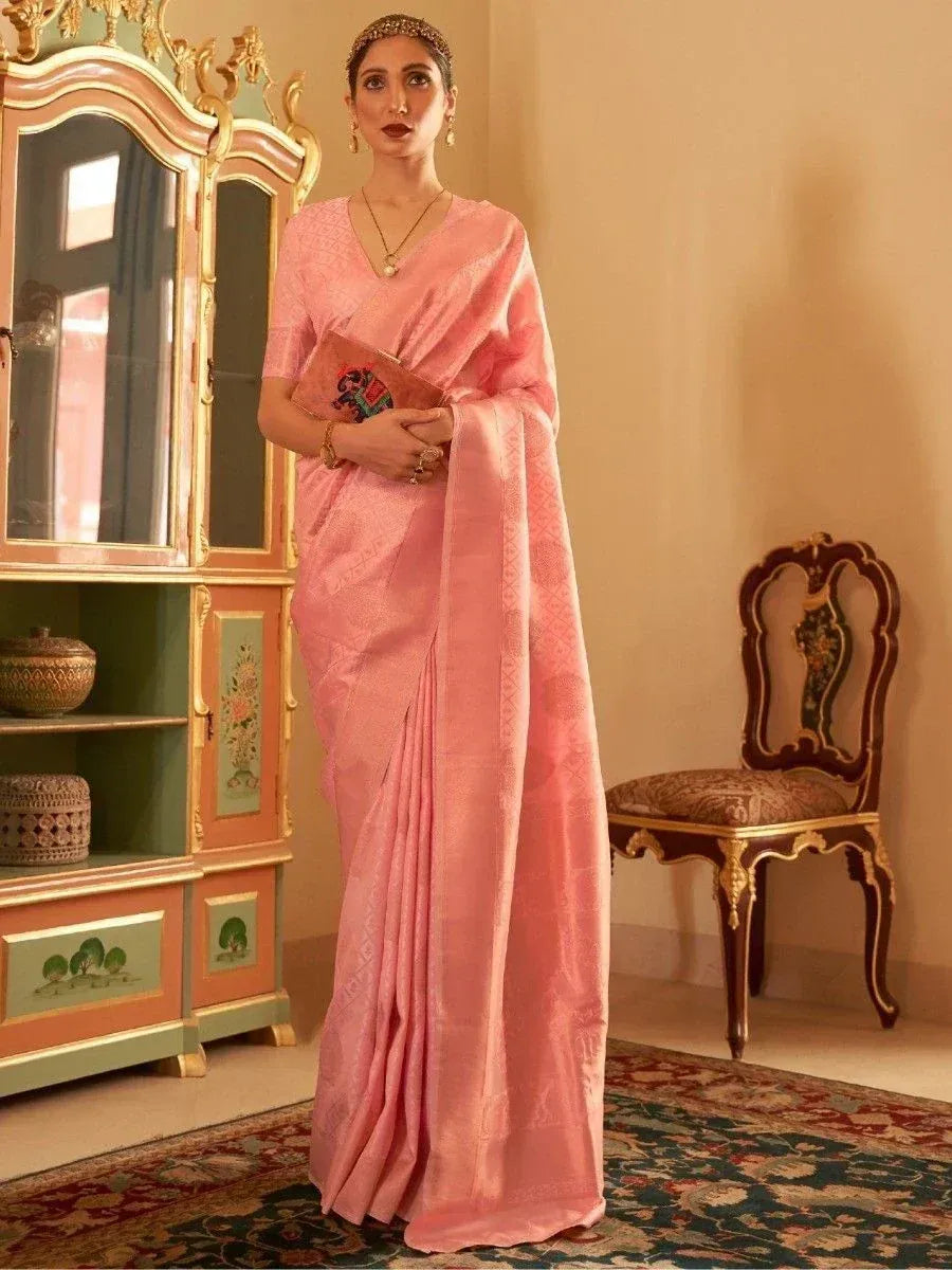 Pink designer saree with subtle weave, styled with gold jewelry and clutch for ethnic occasions