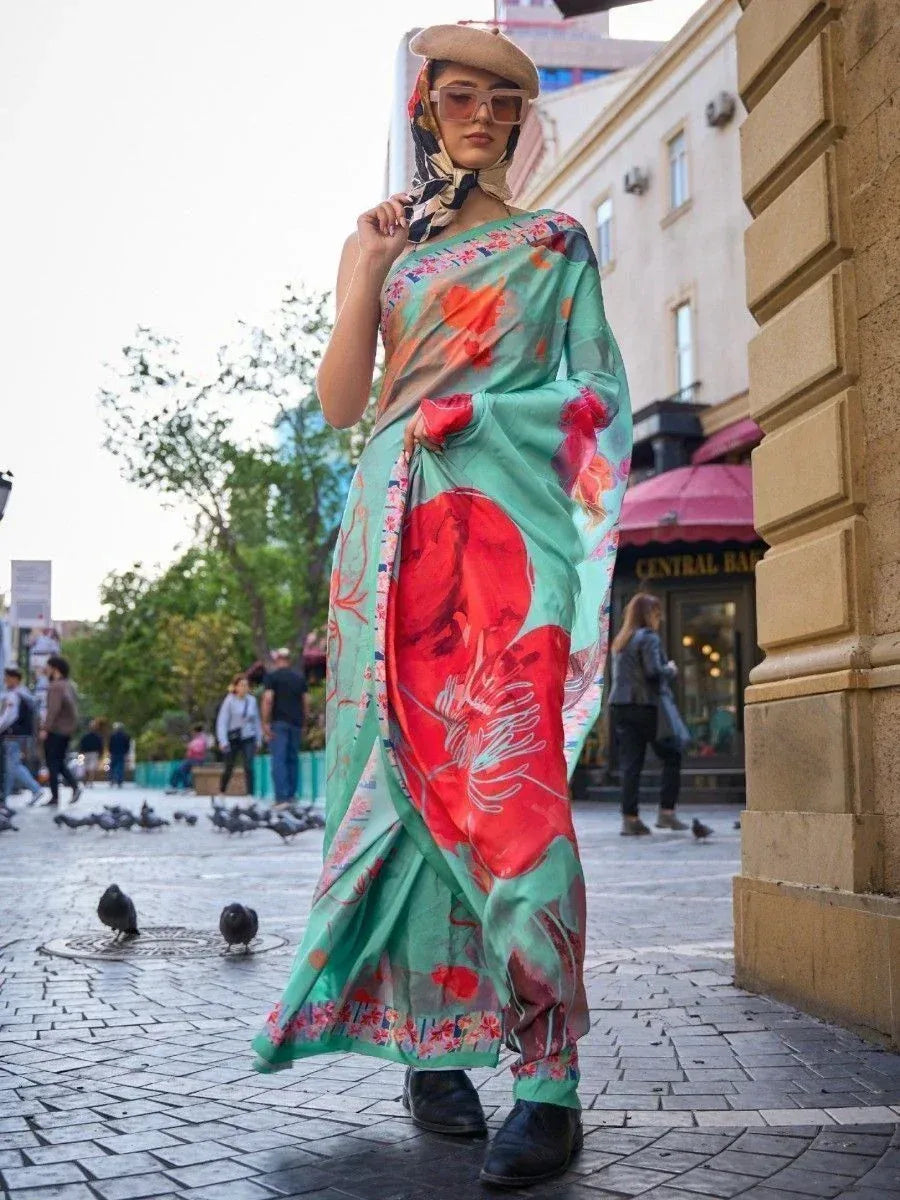 Woman in floral green saree with red print, styled with beret and scarf, walking on city street