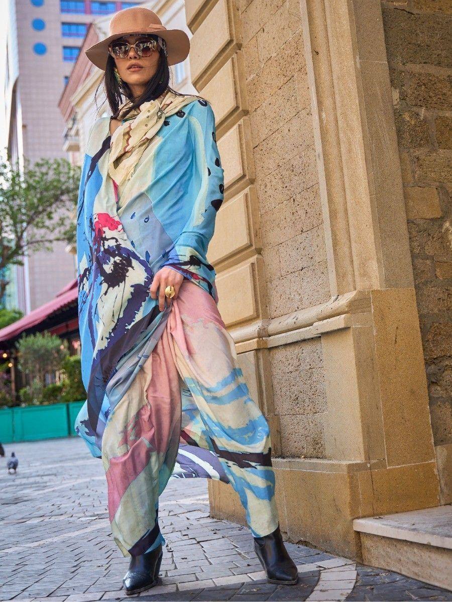 Woman in colorful printed ethnic gown with wide-leg pants, hat, and sunglasses, styled for streetwear fashion