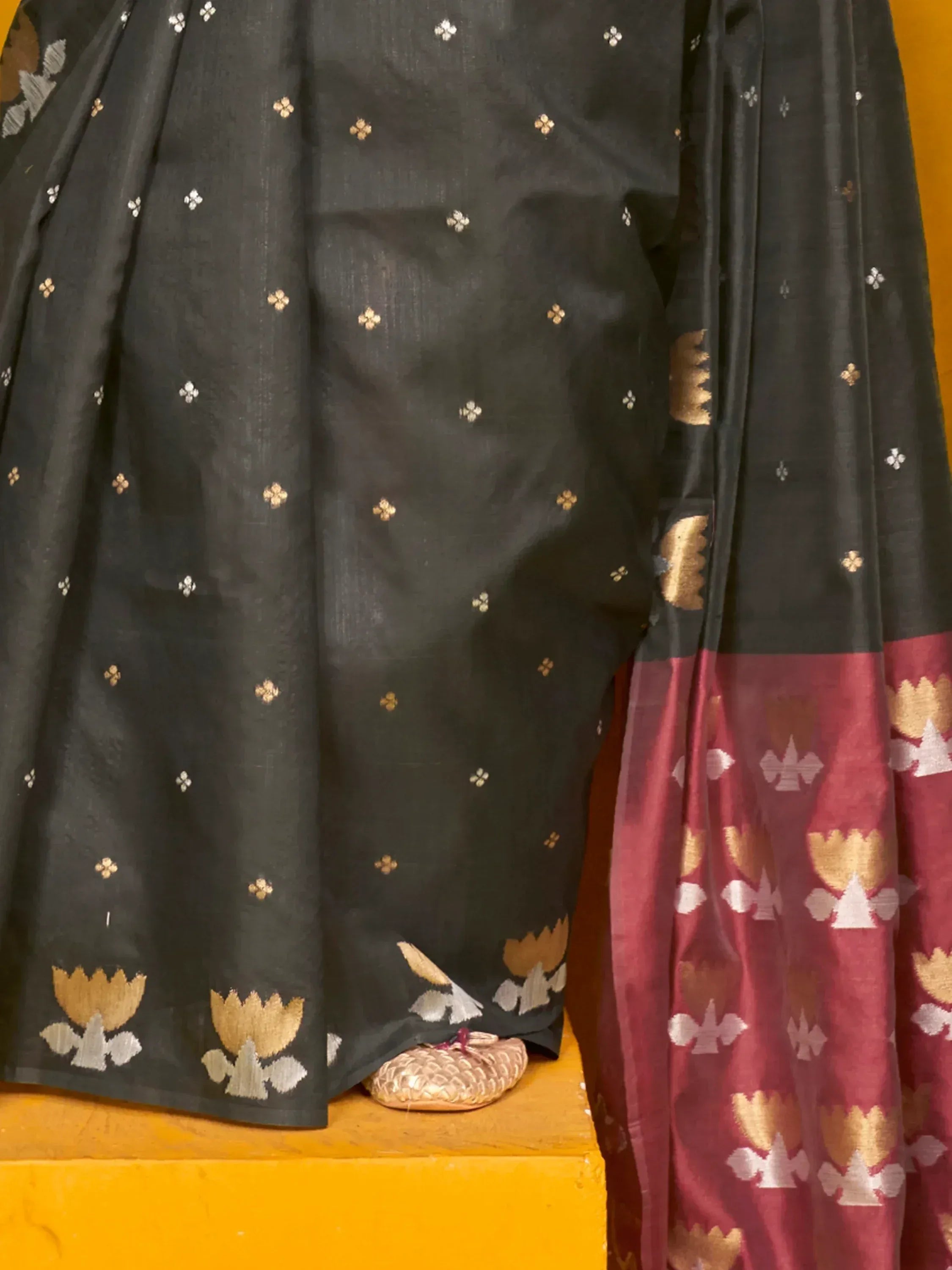 Black and maroon ethnic saree with gold floral motifs and border, traditional Indian wear