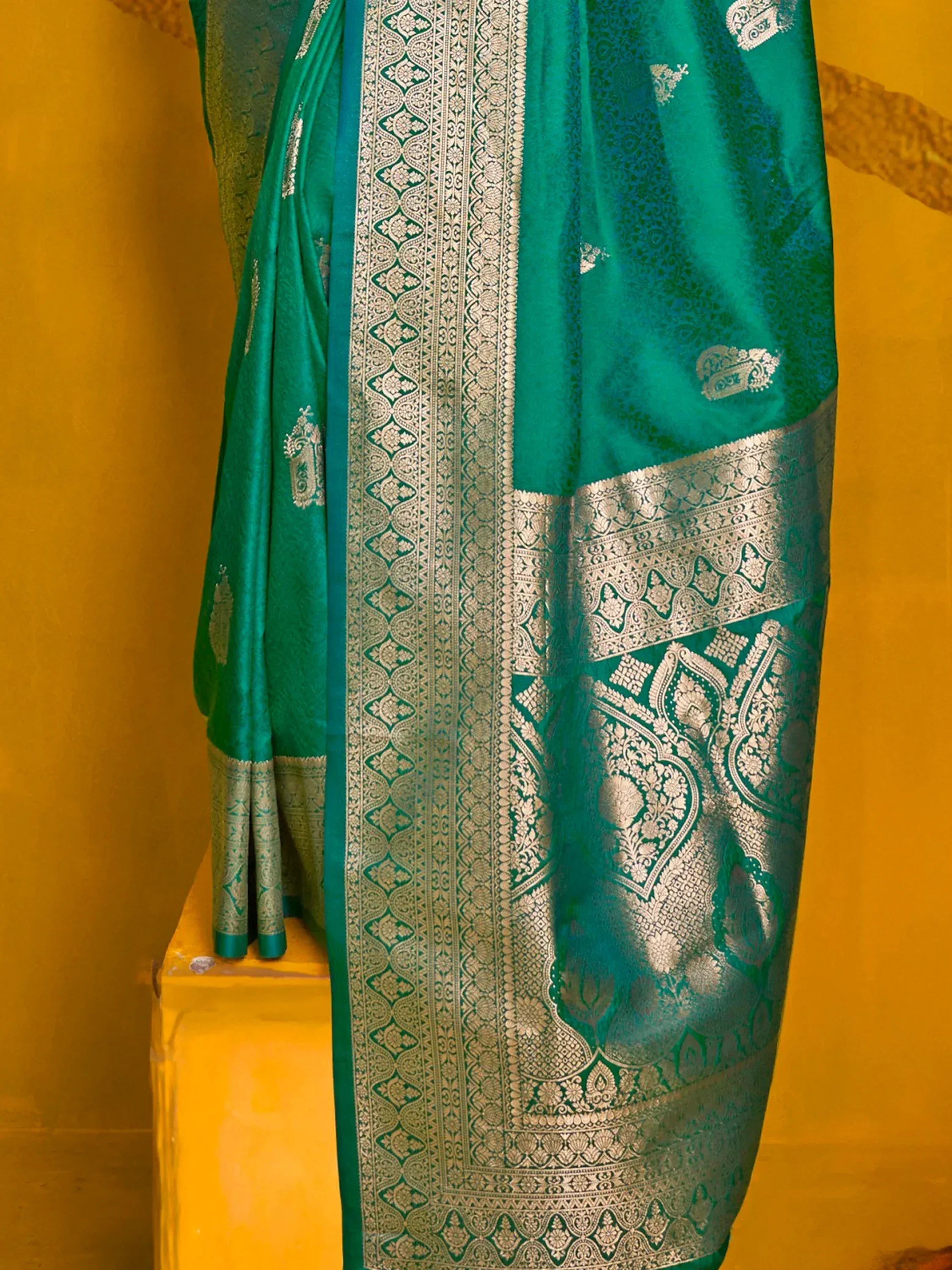 Emerald green designer saree with intricate silver zari work and traditional border, perfect for ethnic occasions.