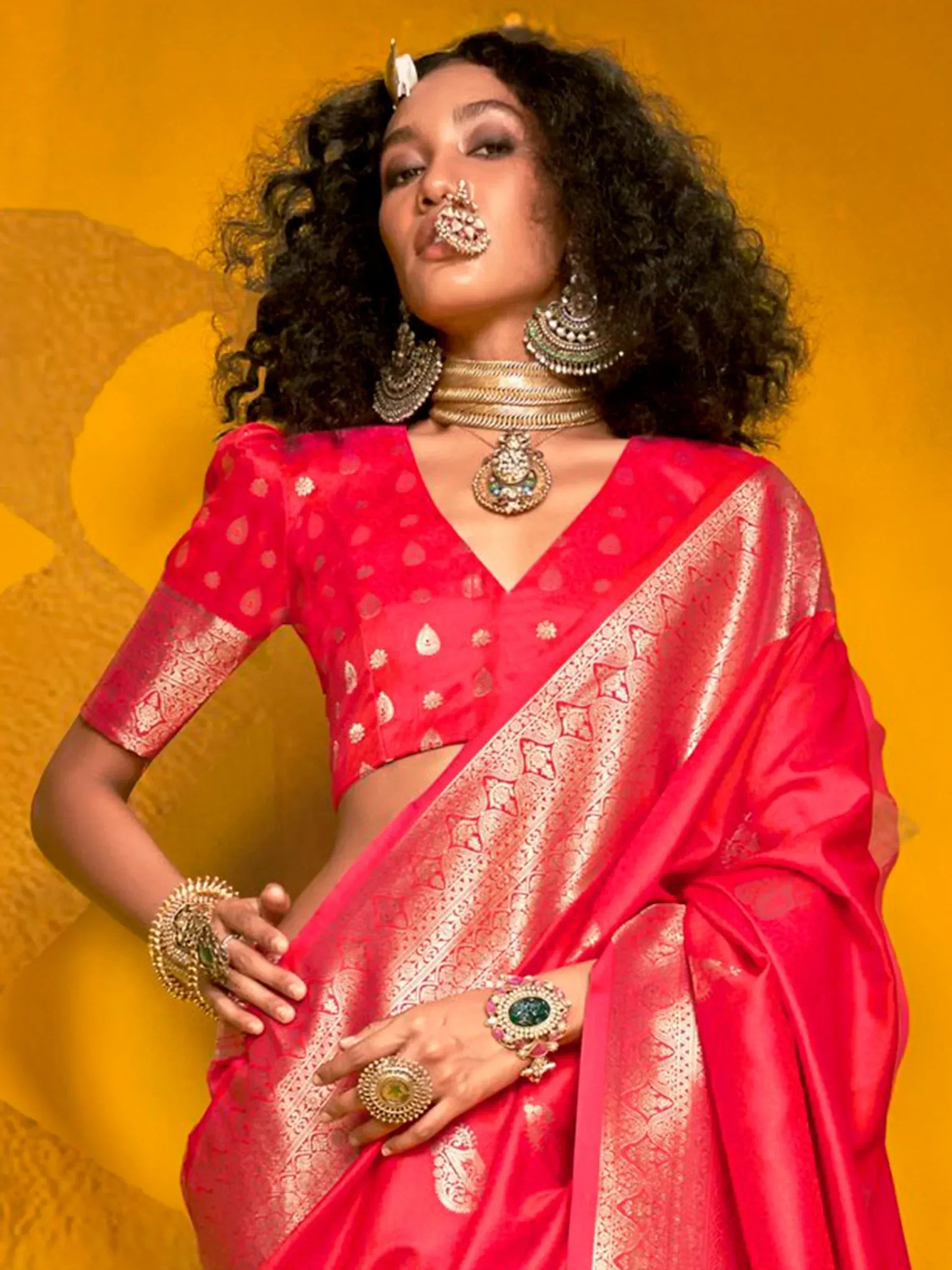 Red designer saree with gold embroidery, paired with traditional Indian jewelry for ethnic wear