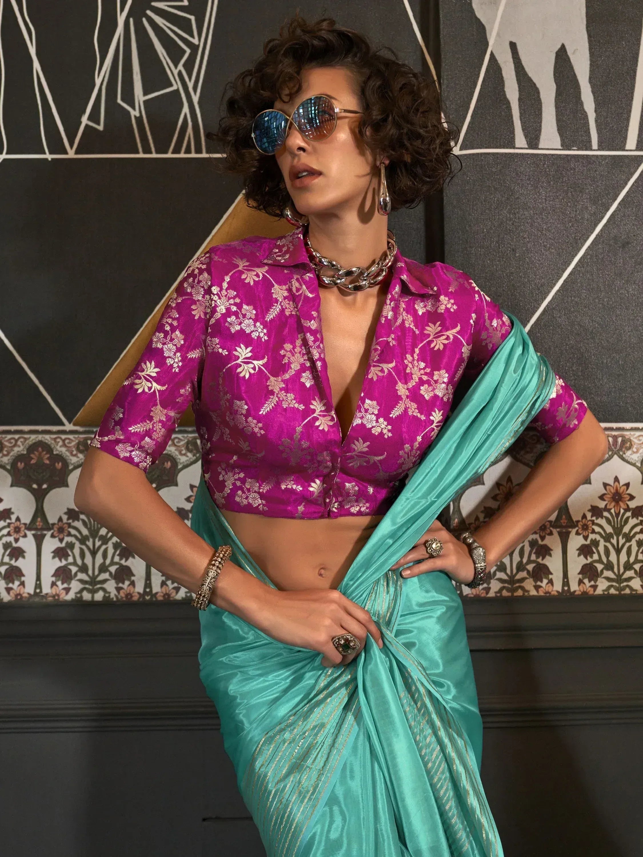 Woman in turquoise saree with gold stripes and magenta floral blouse, stylish ethnic wear