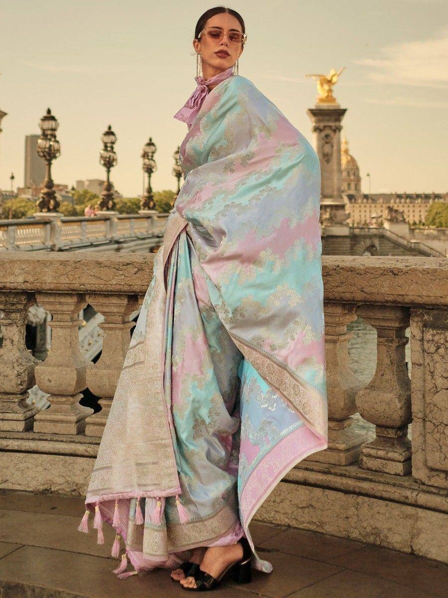 Pastel blue and pink designer saree with gold embroidery, tassels, and modern drape on bridge