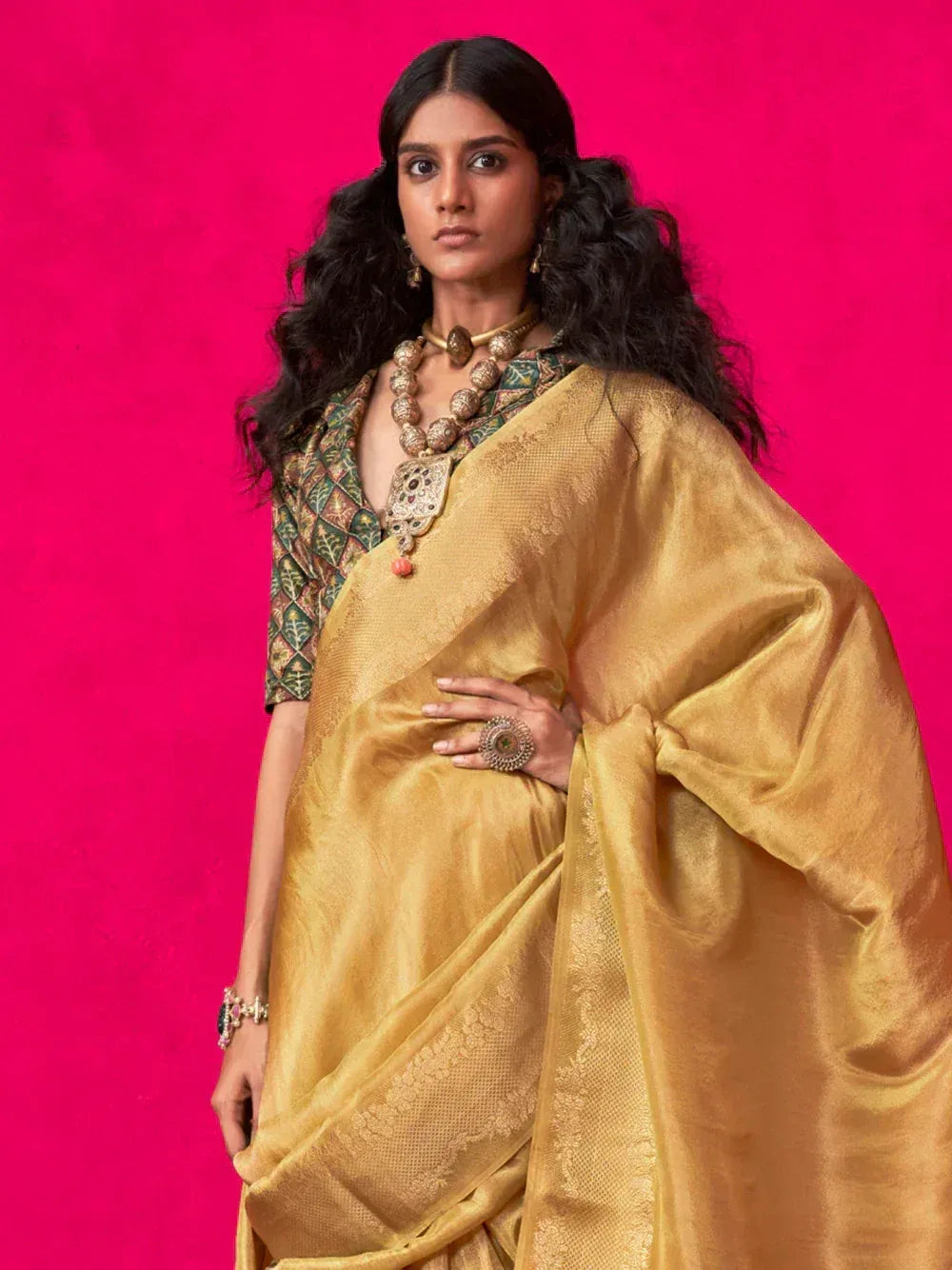 Golden ethnic saree with patterned blouse and traditional jewelry, perfect for Indian occasions