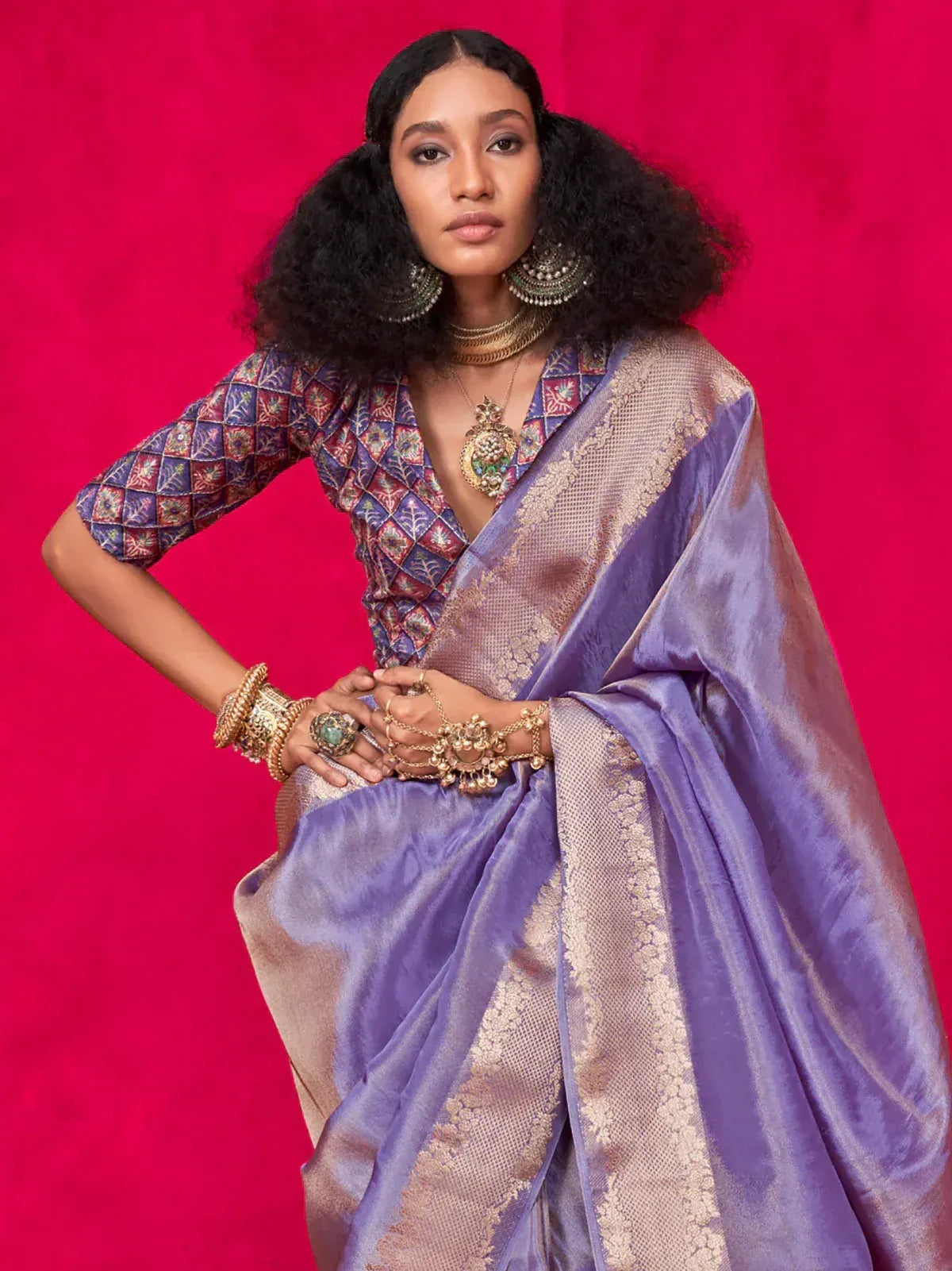 Purple silk saree with gold border, paired with embroidered blouse and traditional jewelry
