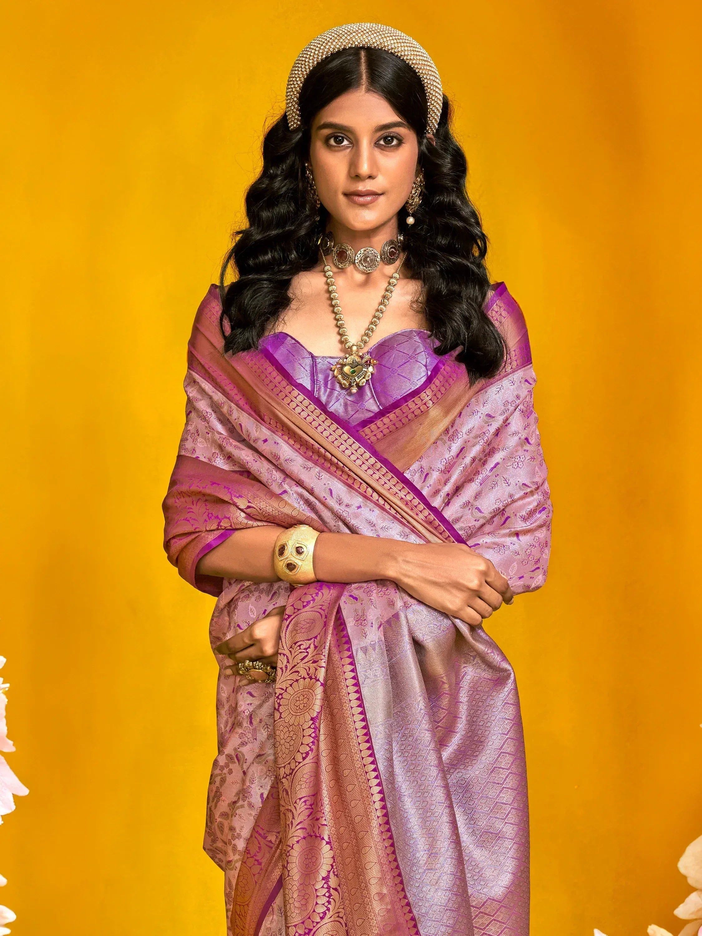 Elegant purple saree with gold embroidery, paired with traditional jewelry and a beaded headband.