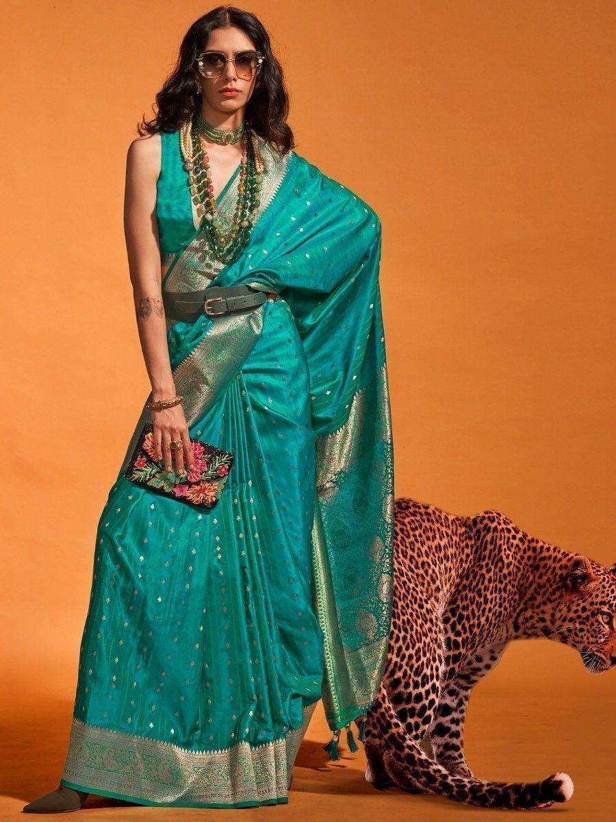 Teal saree with gold embroidery, floral clutch, and leopard backdrop for ethnic wear styling