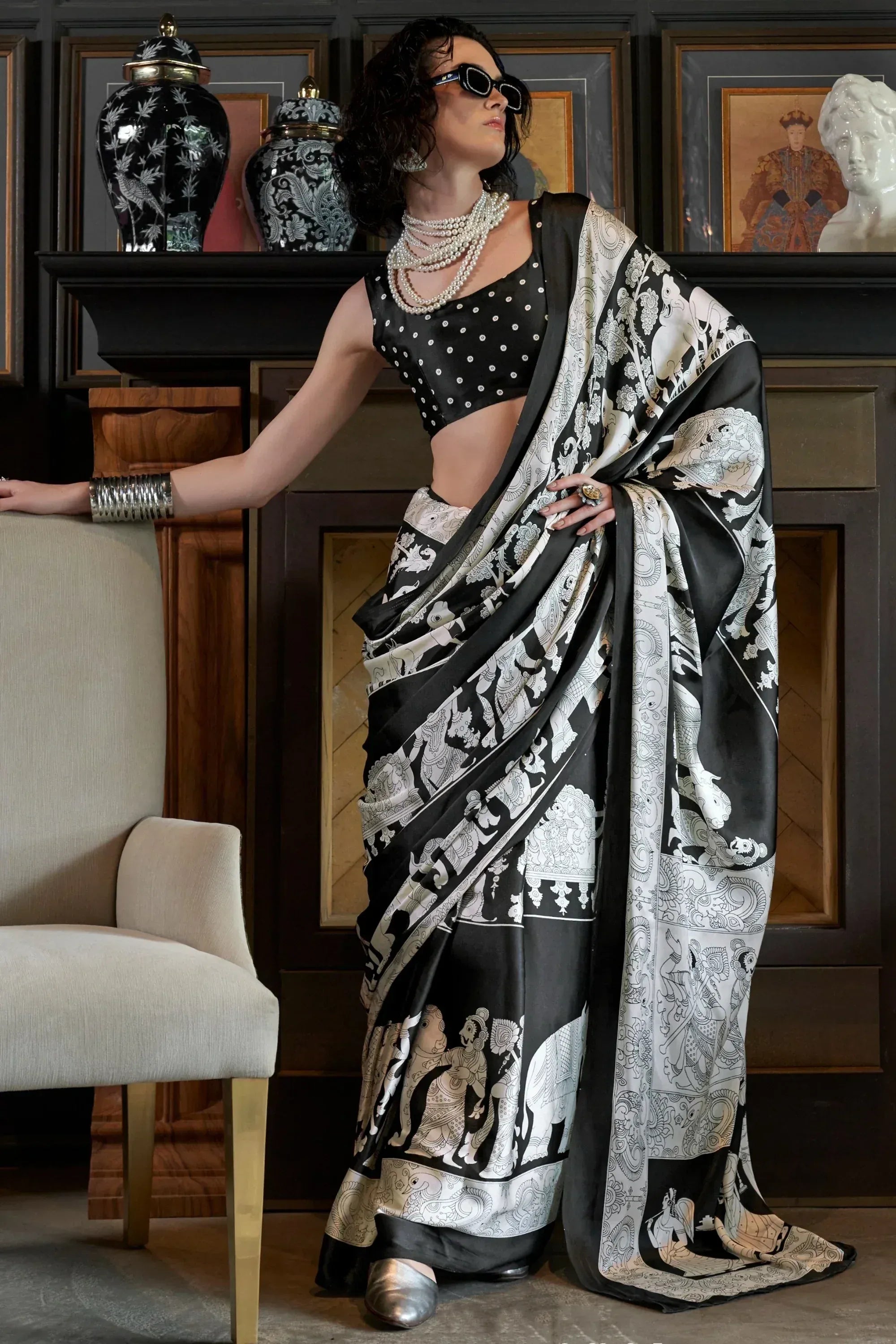 Black and white printed saree with elephant motifs, paired with polka dot blouse and pearl jewelry