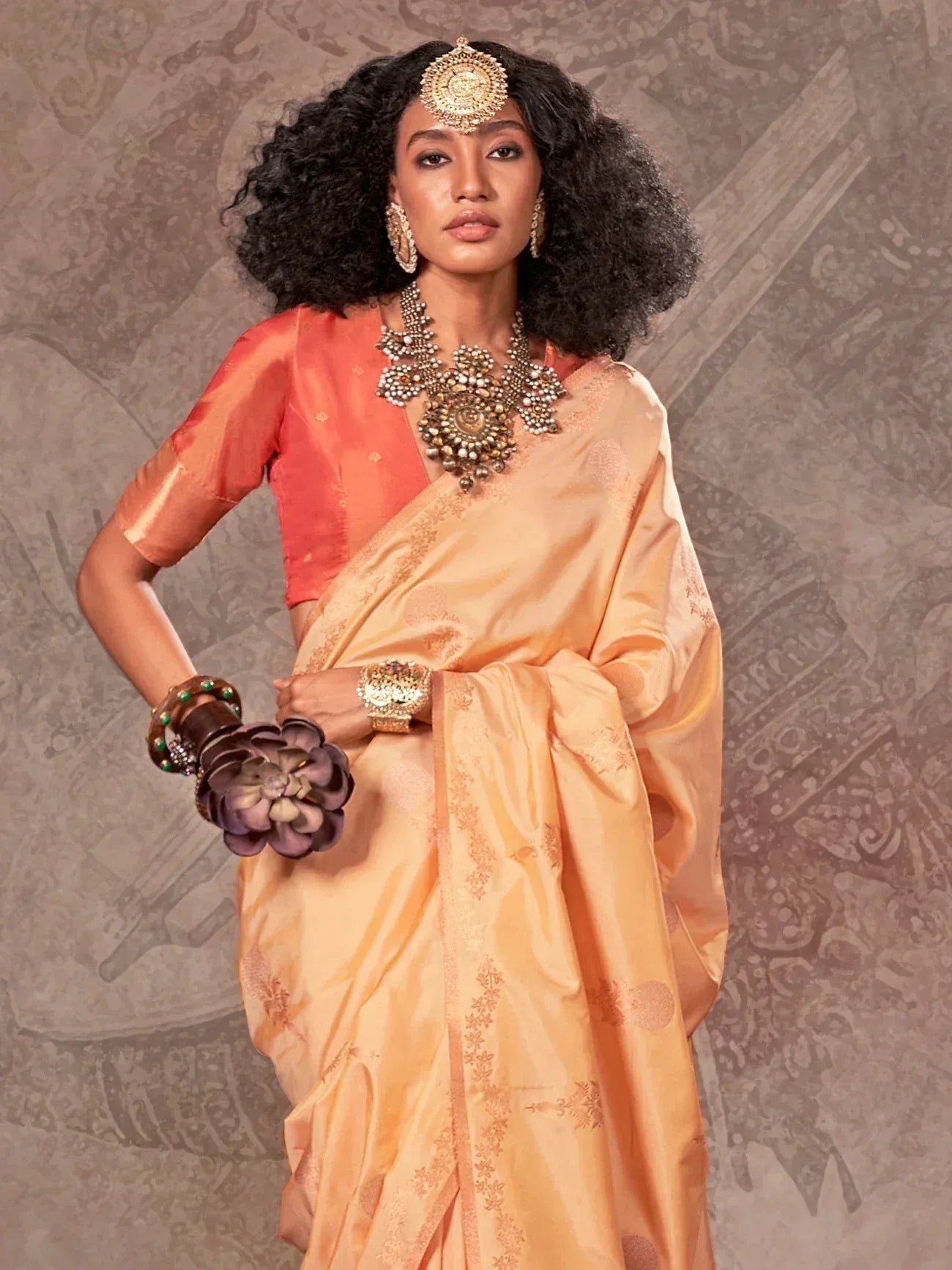 Elegant peach saree with gold embroidery, paired with designer blouse and traditional jewelry for Indian ethnic wear
