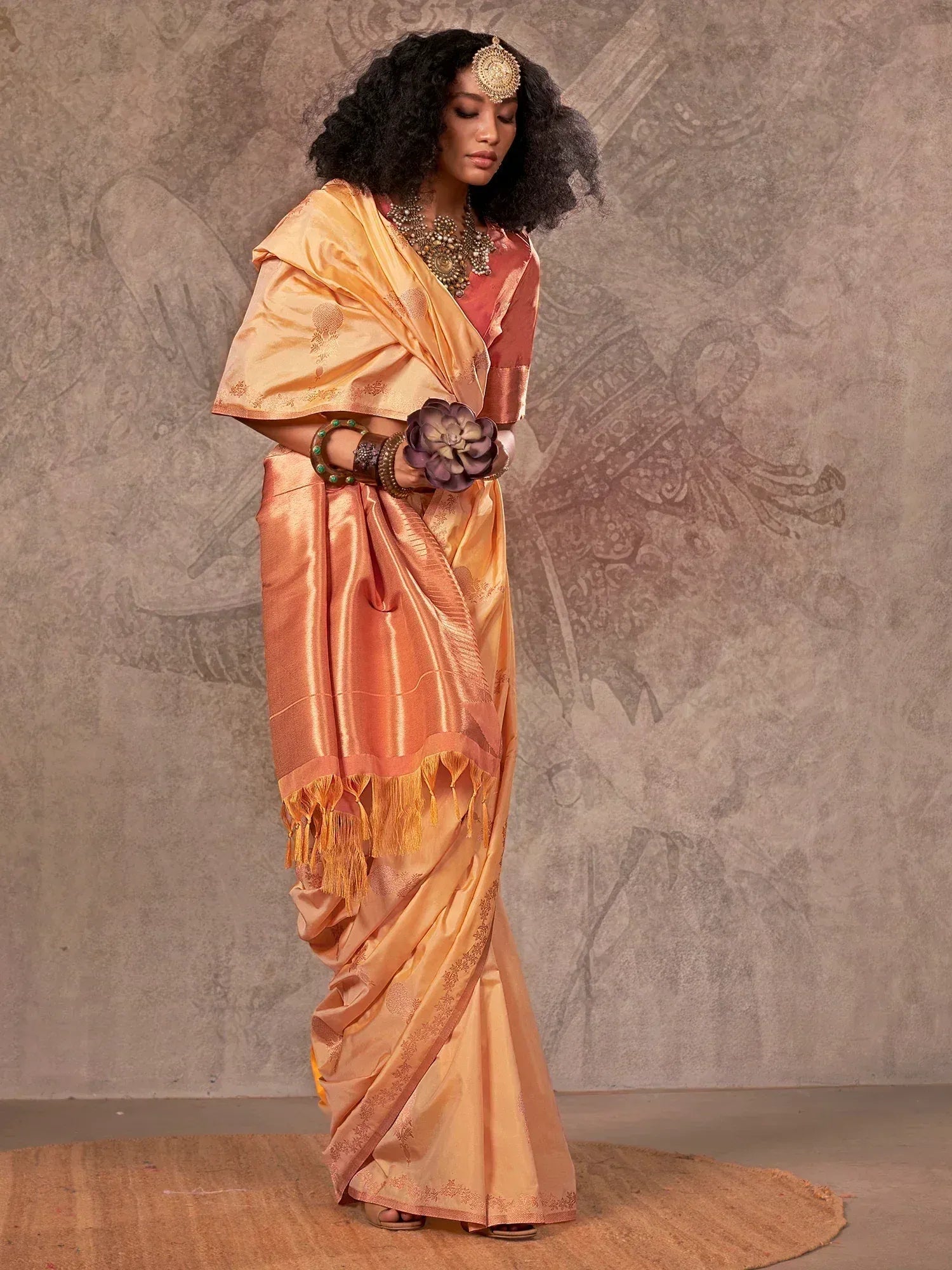Elegant peach and gold silk saree with temple border, perfect for Indian ethnic occasions