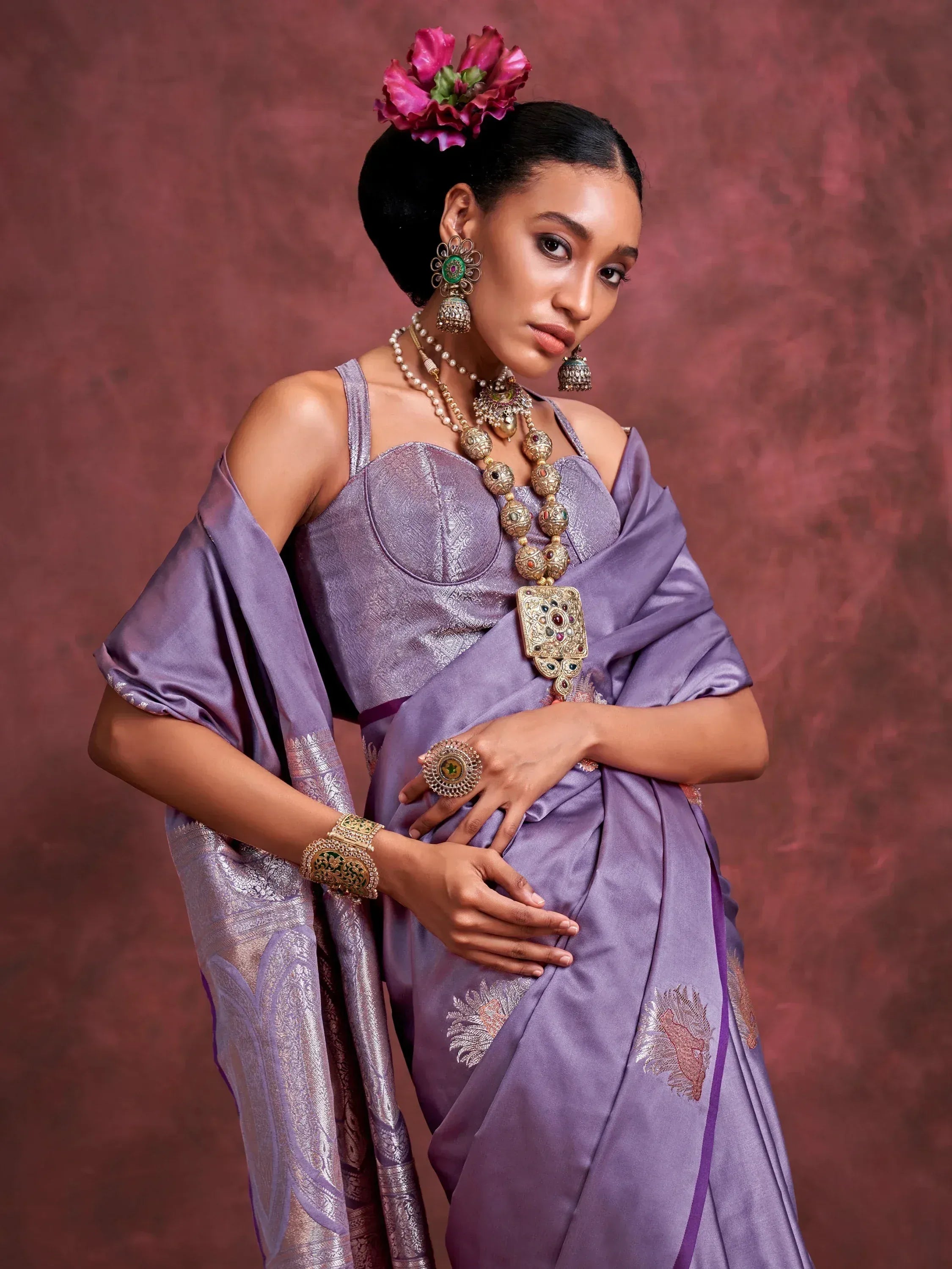 Woman in purple designer saree with floral hair accessory and traditional jewelry, ethnic wear