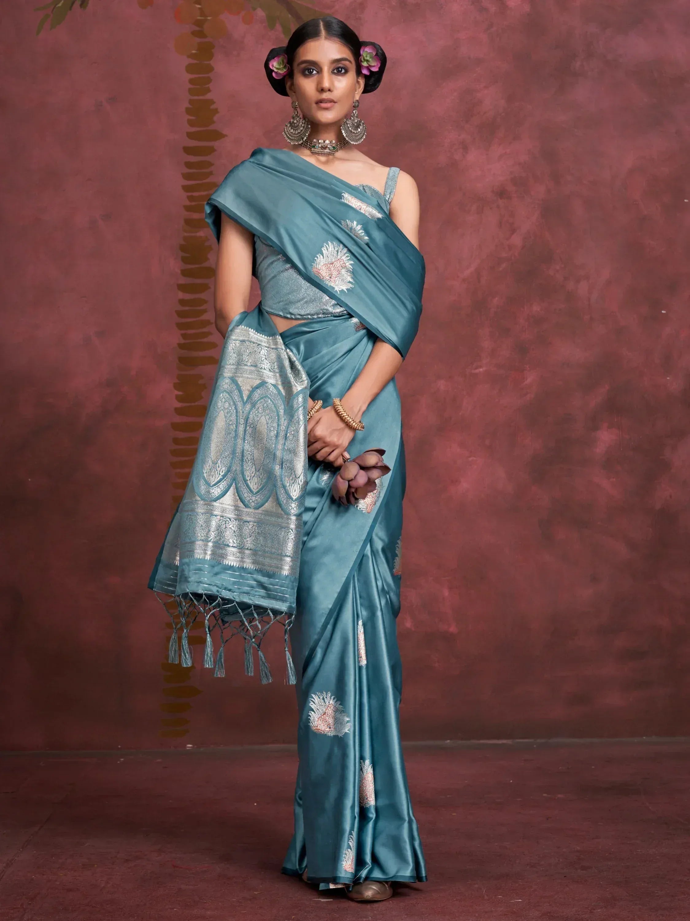 Teal silk saree with silver embroidery and tassels, styled with traditional jewelry for ethnic wear