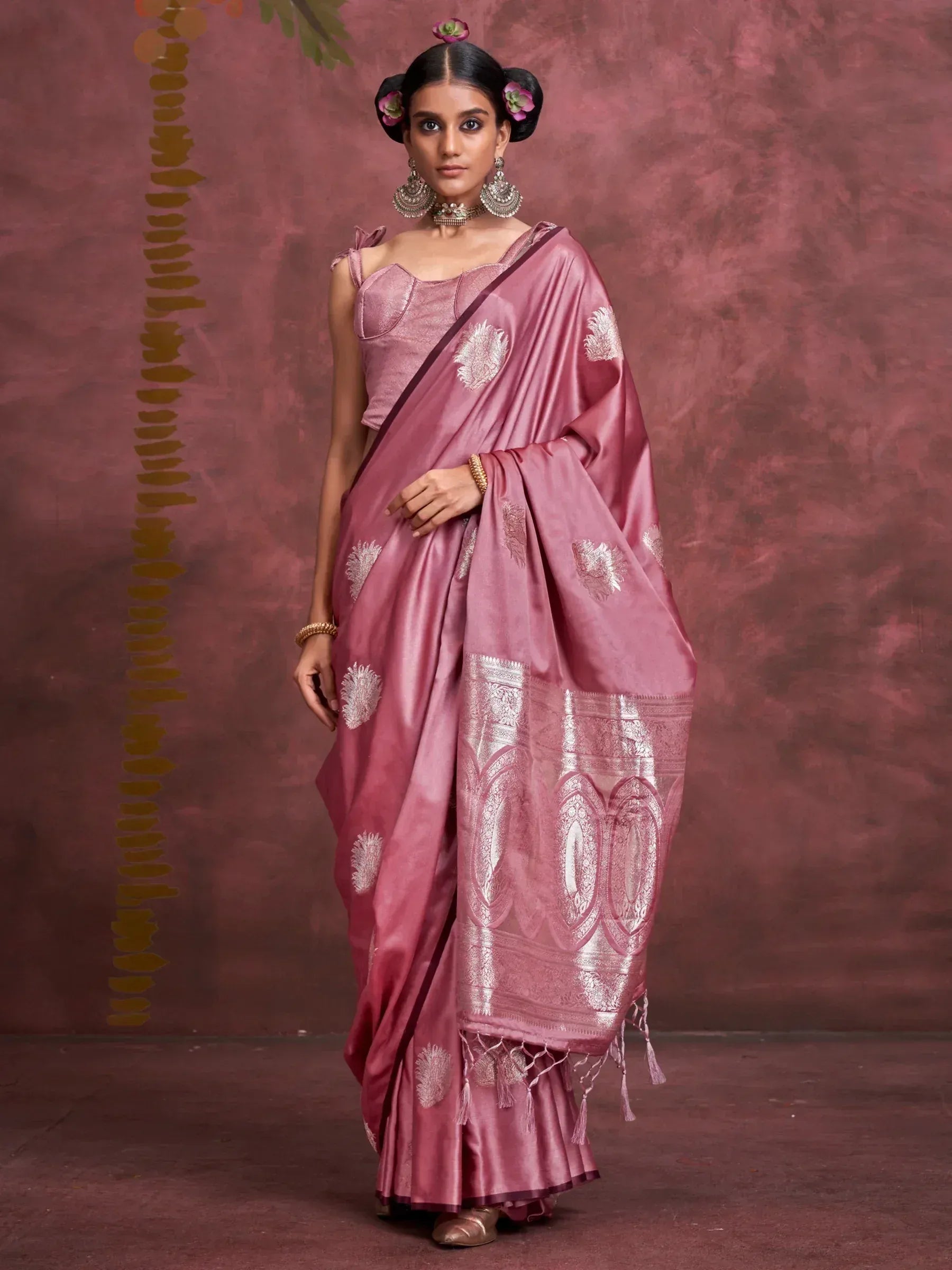 Pink silk saree with gold embroidery and tassels, paired with matching blouse and traditional jewelry