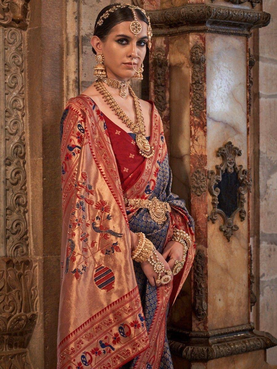 Elegant Indian bride in embroidered red and gold saree with traditional jewelry and maang tikka