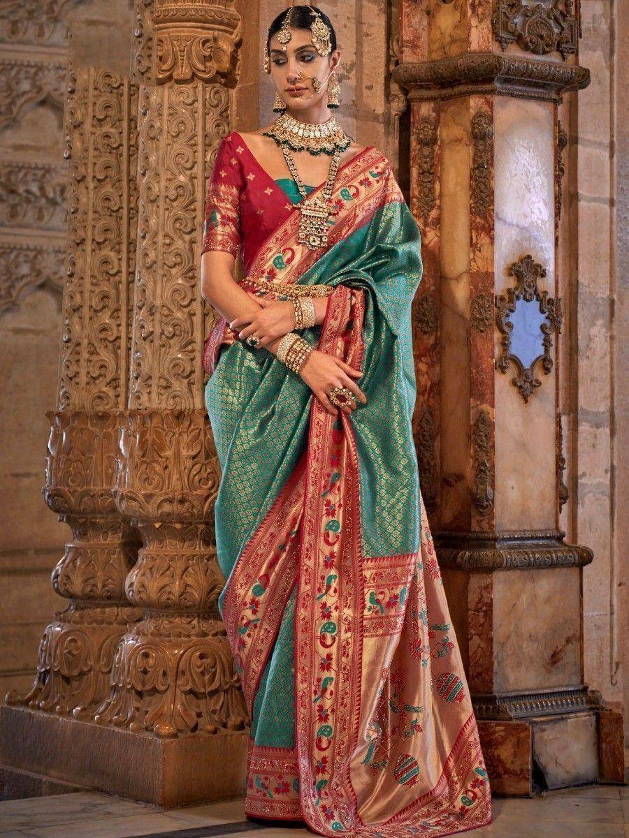 Elegant teal and red designer saree with intricate embroidery, paired with traditional jewelry for ethnic wear.