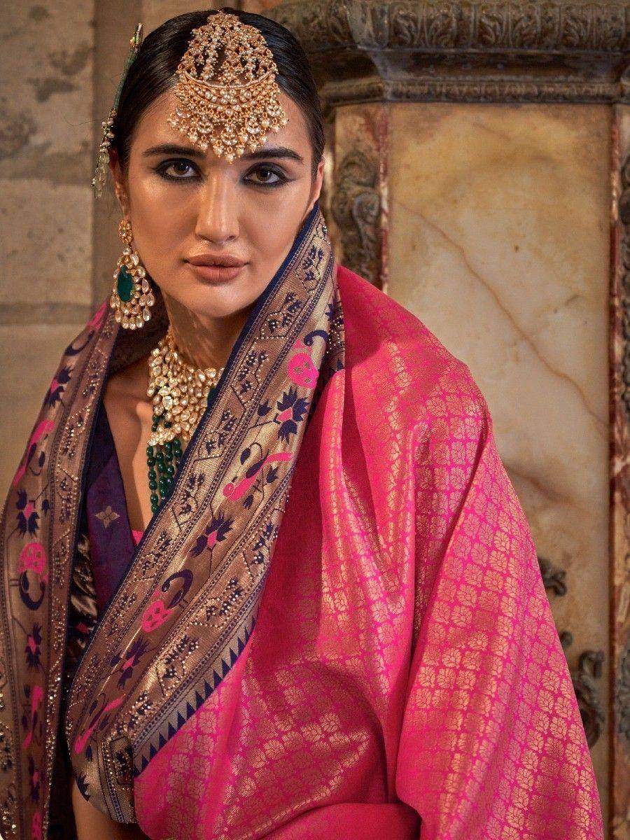 Woman in vibrant pink ethnic saree with gold embroidery, traditional jewelry, and ornate headpiece