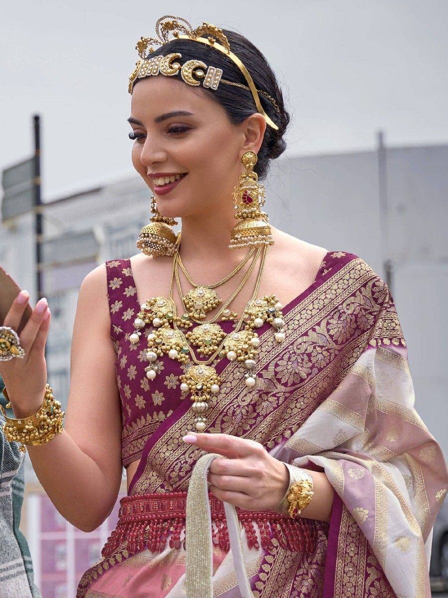 Woman in maroon and gold designer lehenga choli with heavy traditional jewelry, perfect for Indian weddings