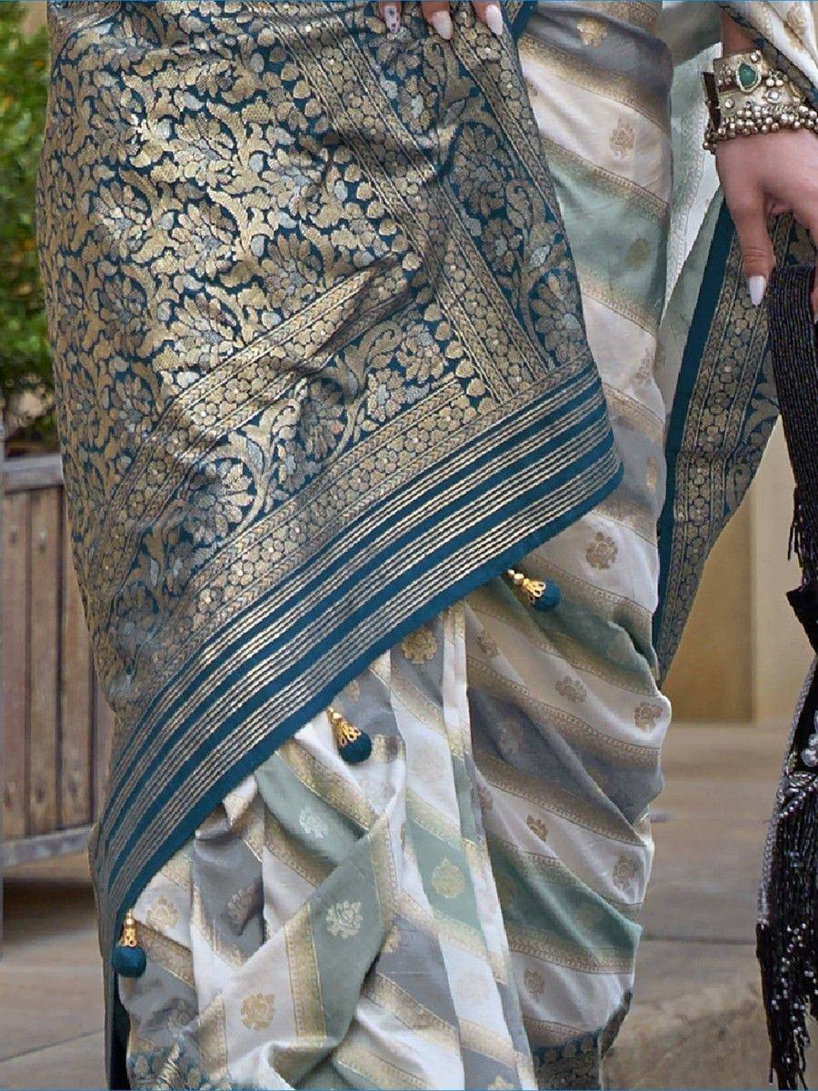 Elegant teal and gold brocade saree with intricate floral patterns and tassels, perfect for Indian ethnic wear.