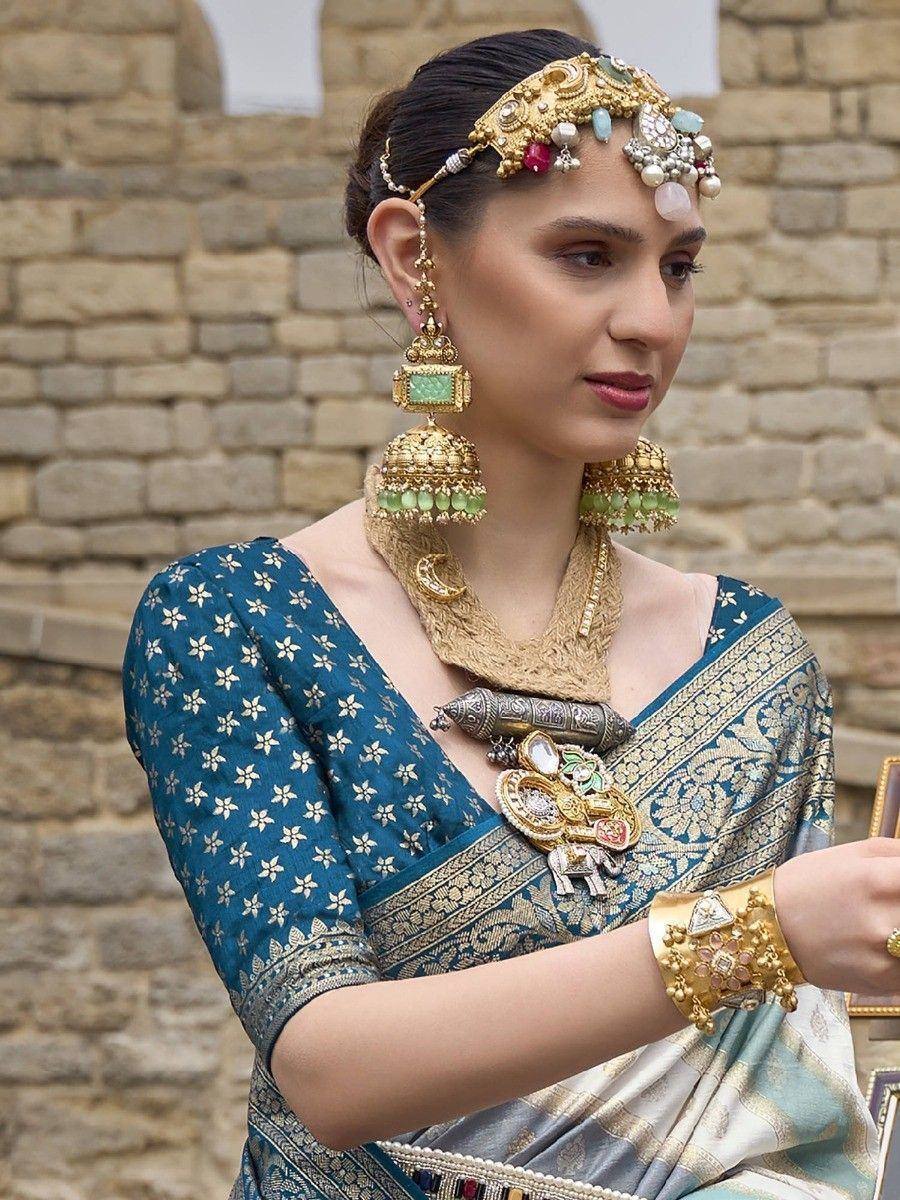 Woman in blue floral saree with gold temple jewelry, traditional Indian ethnic wear