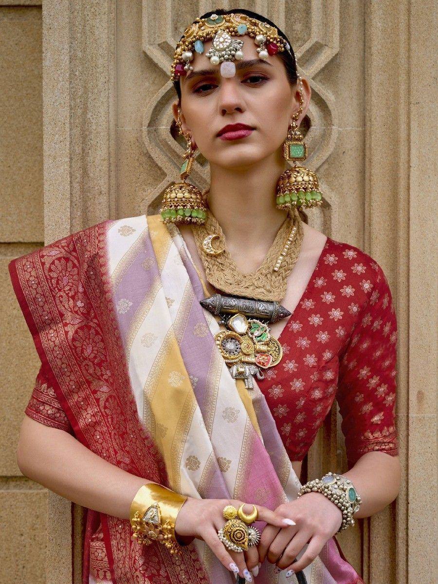 Woman in red floral blouse with multicolor saree, traditional Indian jewelry, and ornate headpiece
