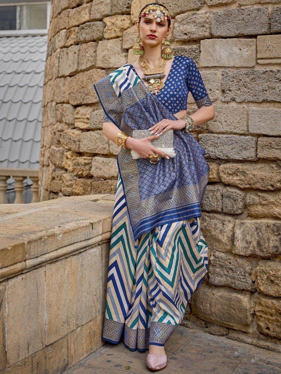 Blue and teal patterned saree with geometric print, styled with gold jewelry and traditional headpiece