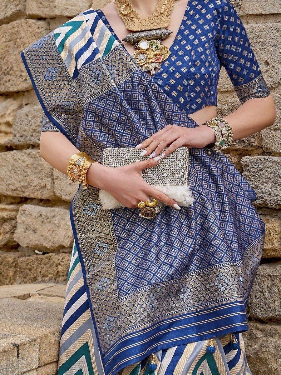 Blue patterned saree with gold jewelry and clutch, ethnic Indian wear
