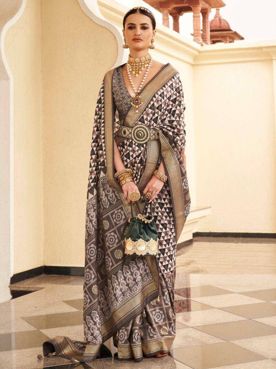 Elegant Indian saree with geometric print, gold embroidery, and traditional jewelry for festive occasions