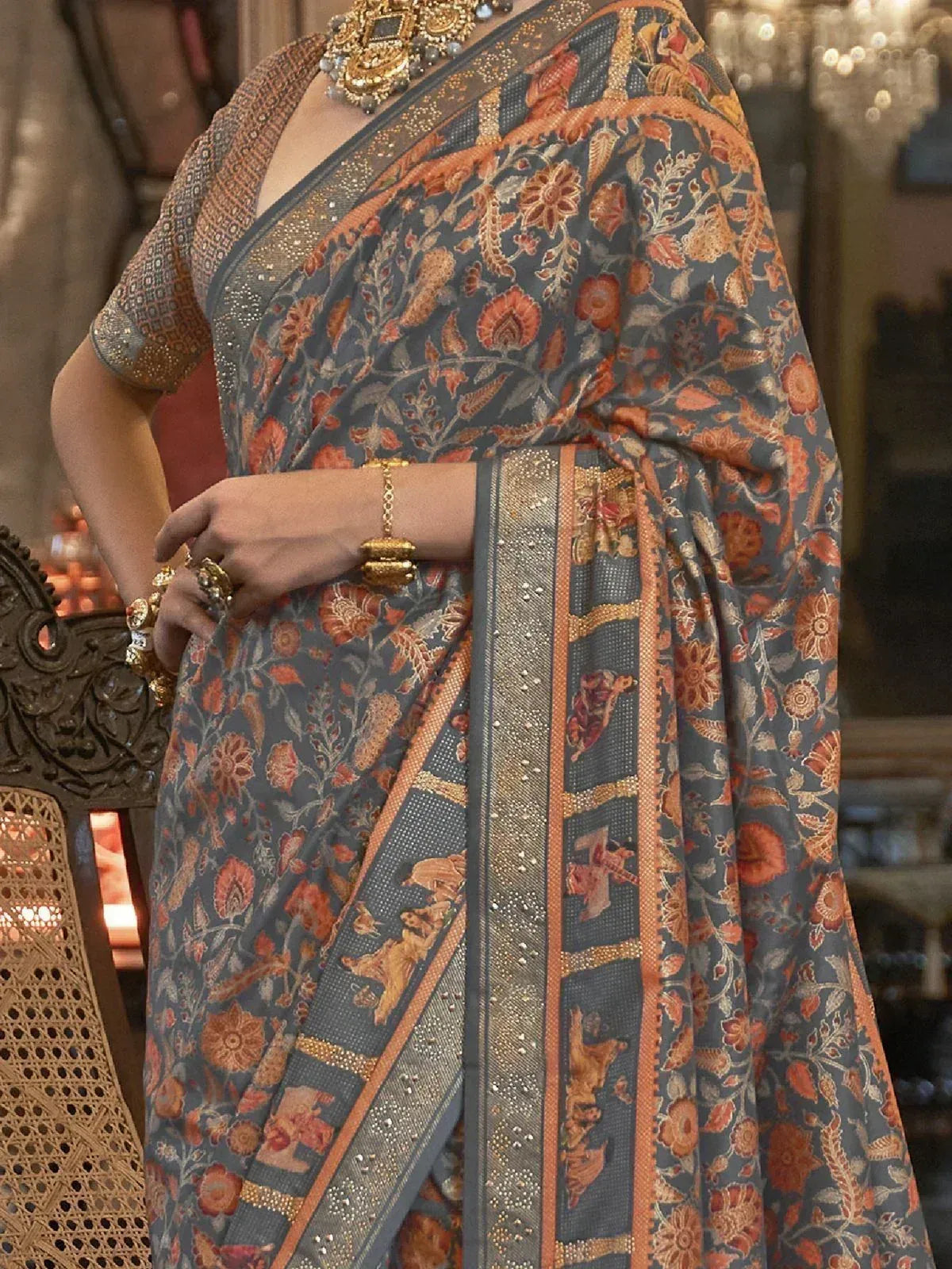 Grey floral saree with gold zari border and elephant motifs, paired with embroidered blouse and traditional jewelry