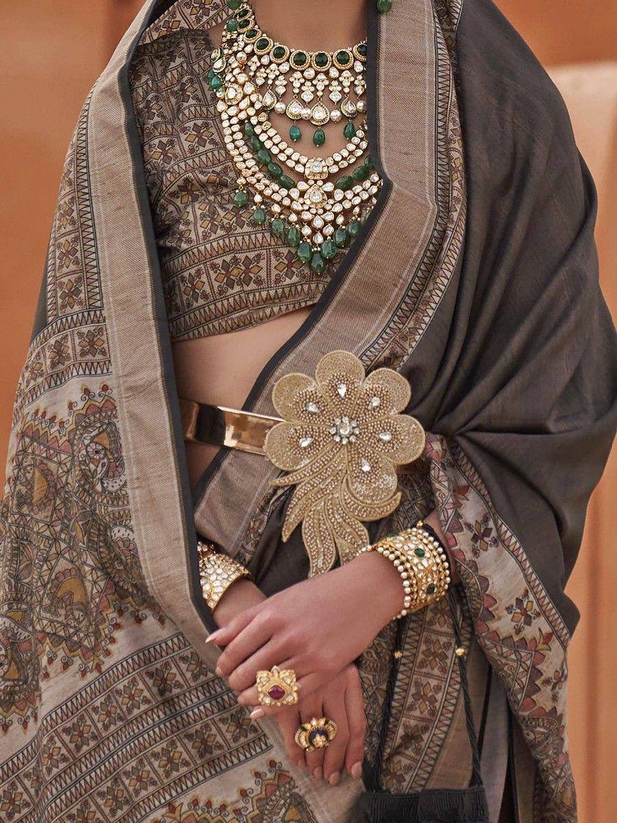 Elegant Indian ethnic wear with intricate jewelry, featuring designer lehenga choli and floral belt.