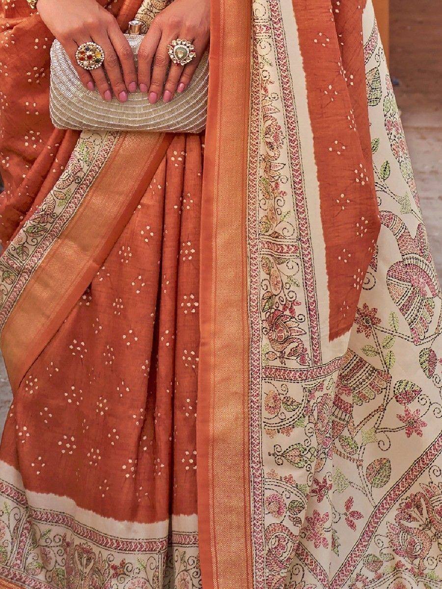 Orange printed saree with floral border, ethnic wear for women, paired with statement rings and clutch