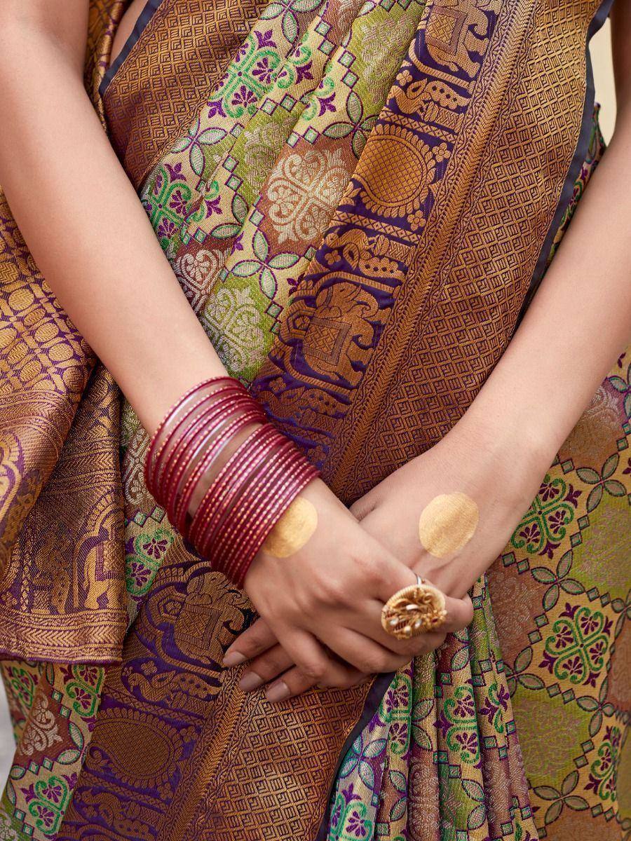 Elegant Indian saree with intricate elephant and floral motifs, paired with red bangles and gold jewelry