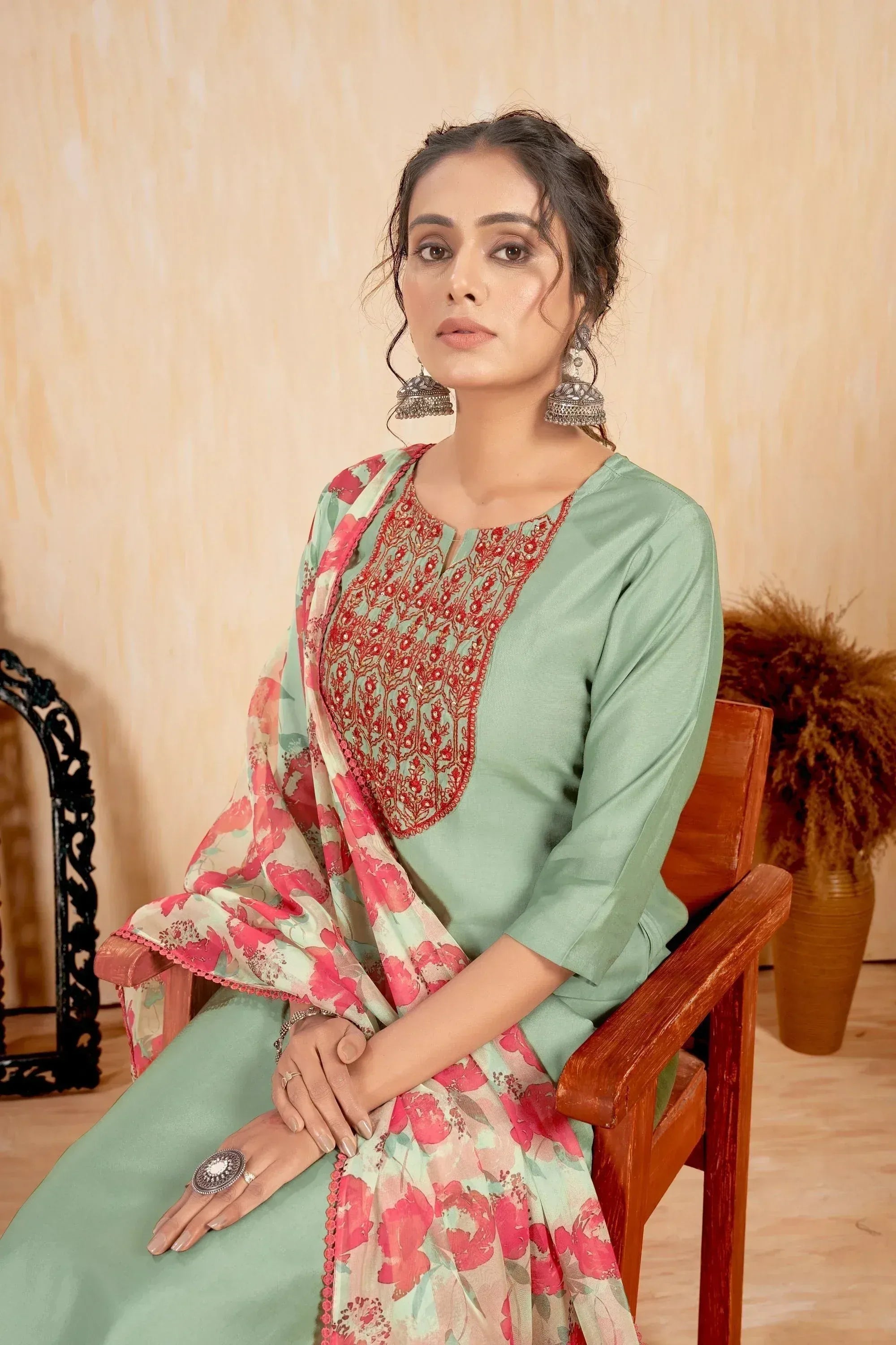 Mint green salwar kameez with red embroidery and floral dupatta, styled with jhumka earrings