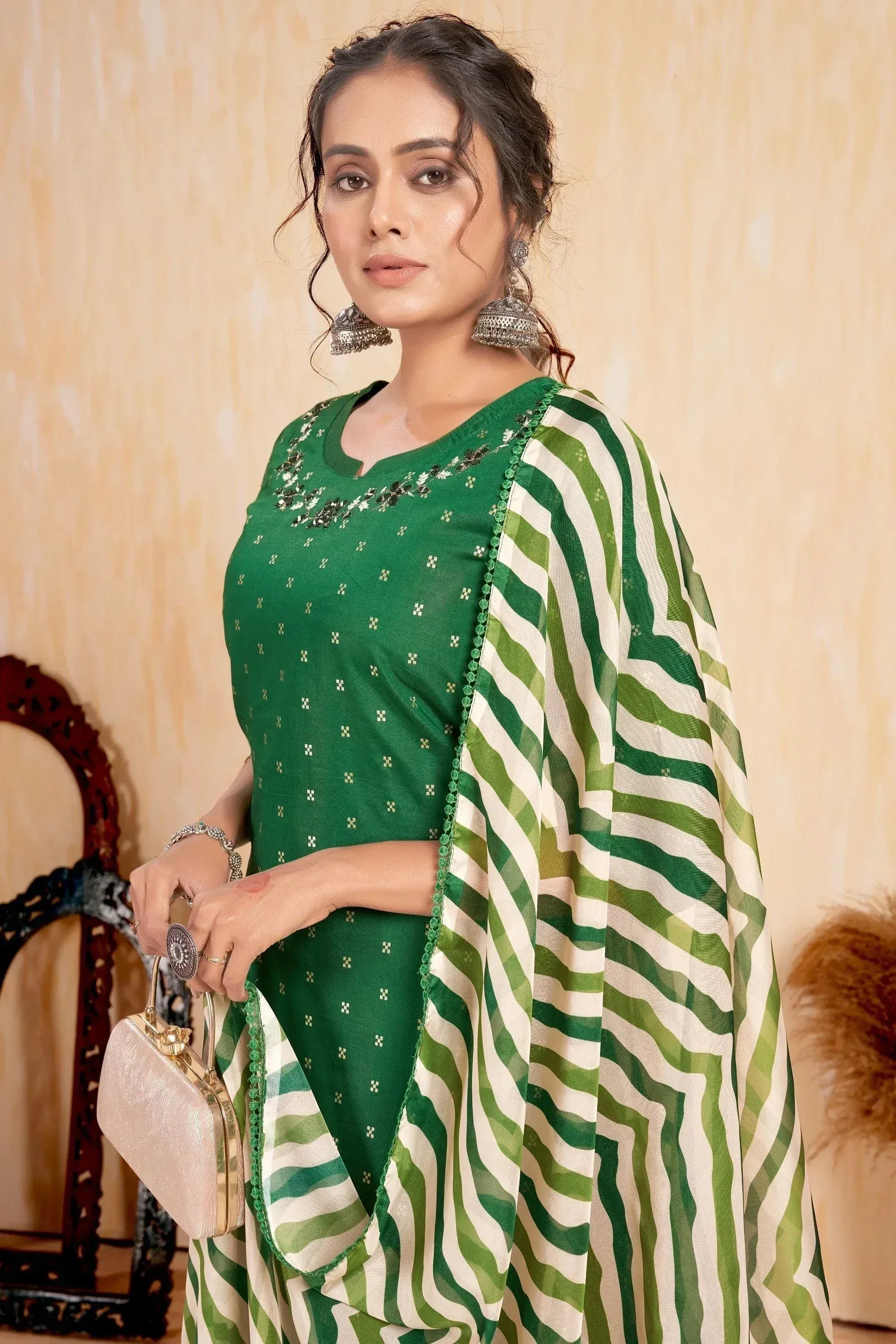 Green ethnic saree with white stripes, embellished blouse, and traditional jewelry