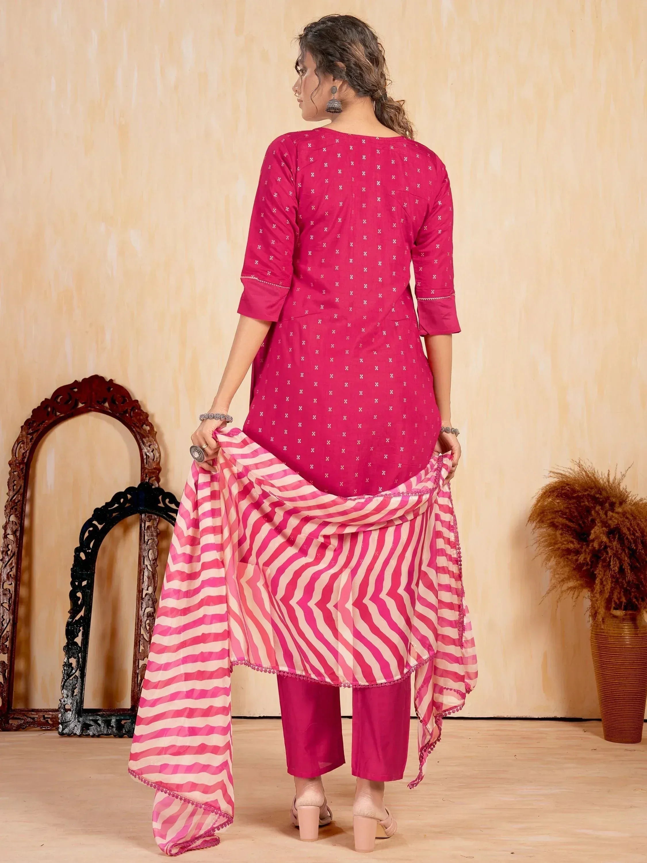 Woman in pink printed salwar kameez suit with striped dupatta, back view