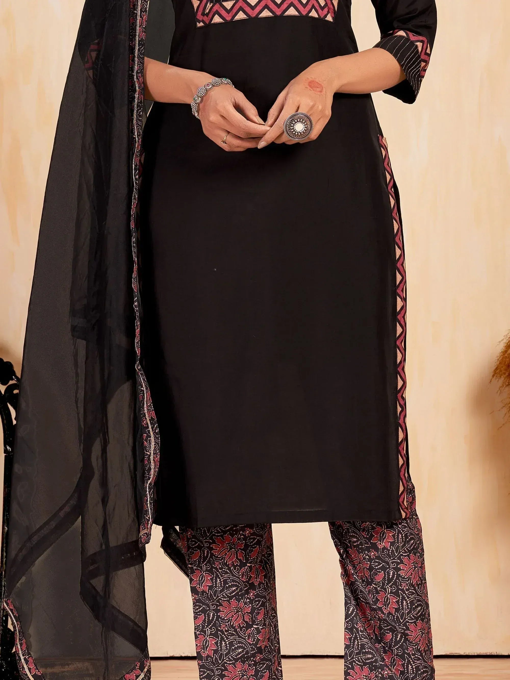 Black ethnic salwar kameez with red zigzag print and floral pants, paired with sheer dupatta