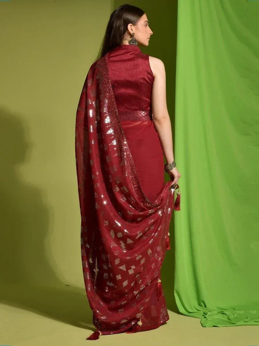 Maroon designer saree with sequin work and tassels, styled with sleeveless blouse for ethnic occasions