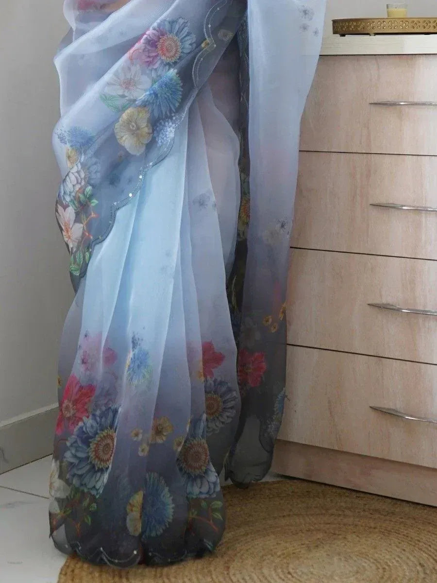 Light blue floral saree with vibrant printed flowers and scalloped border, ideal for ethnic wear occasions