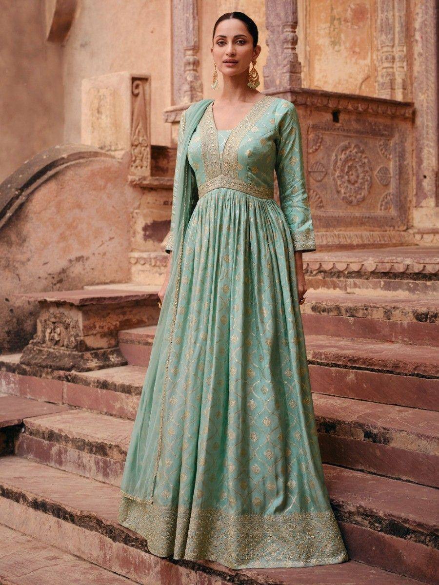 Mint green ethnic gown with gold embroidery, perfect for Indian weddings or festive occasions.
