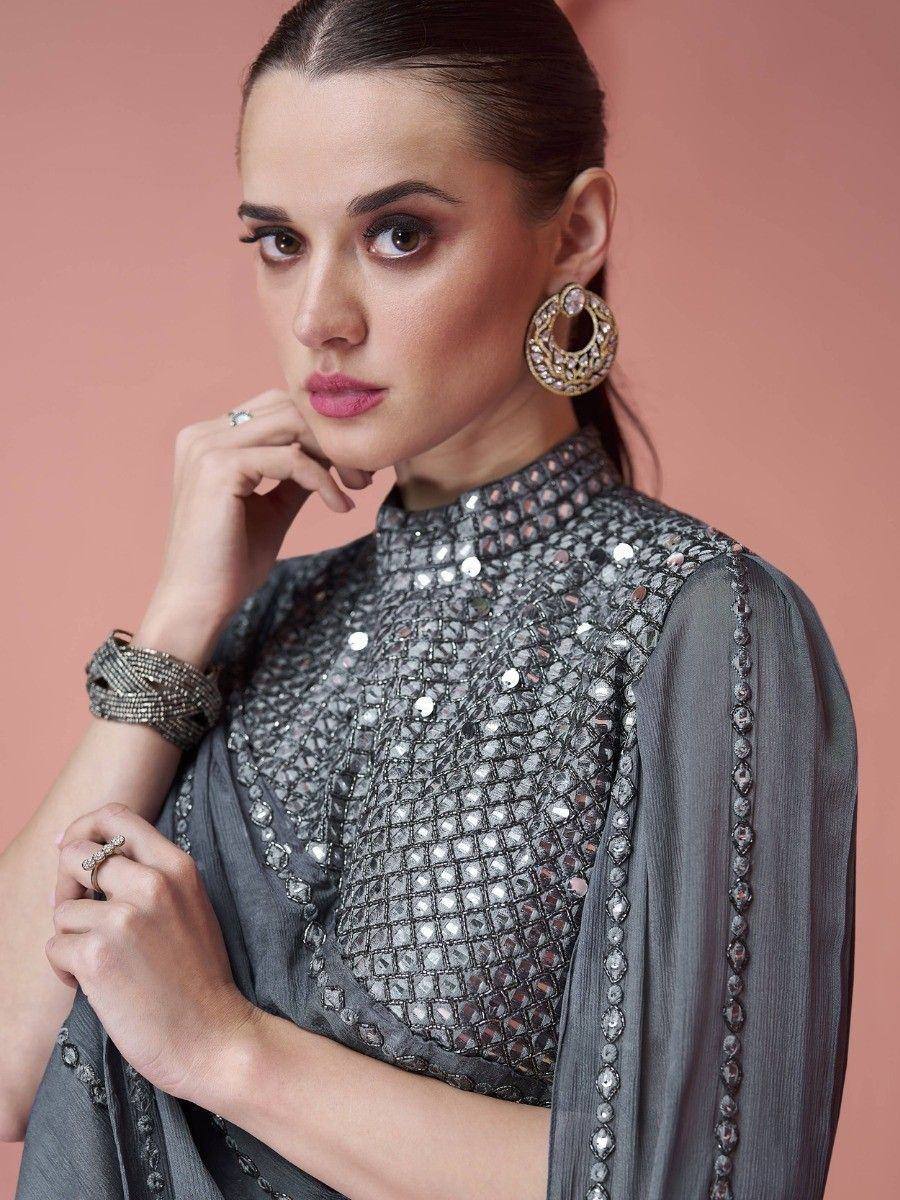 Woman in silver mirror work saree blouse with statement earrings and bracelet